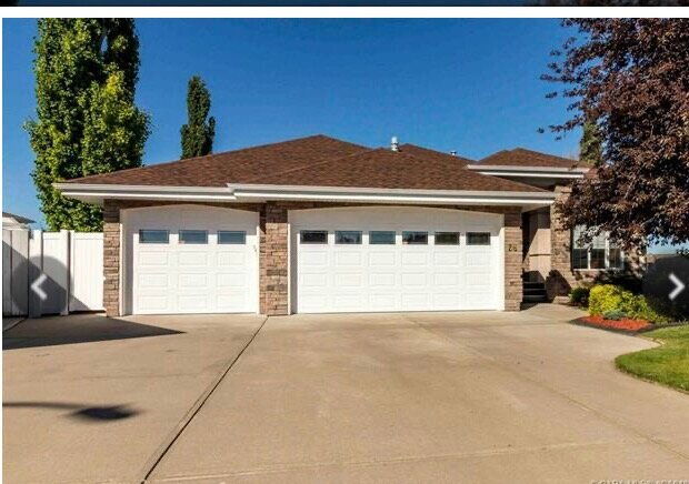 brick bungalow style house with two garage doors