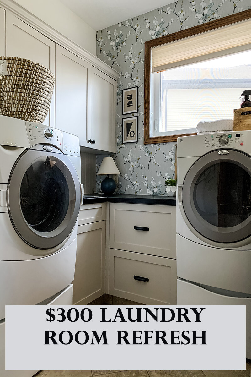 Laundry Room Refresh with painted beige cabinets, black counters, and wallpaper