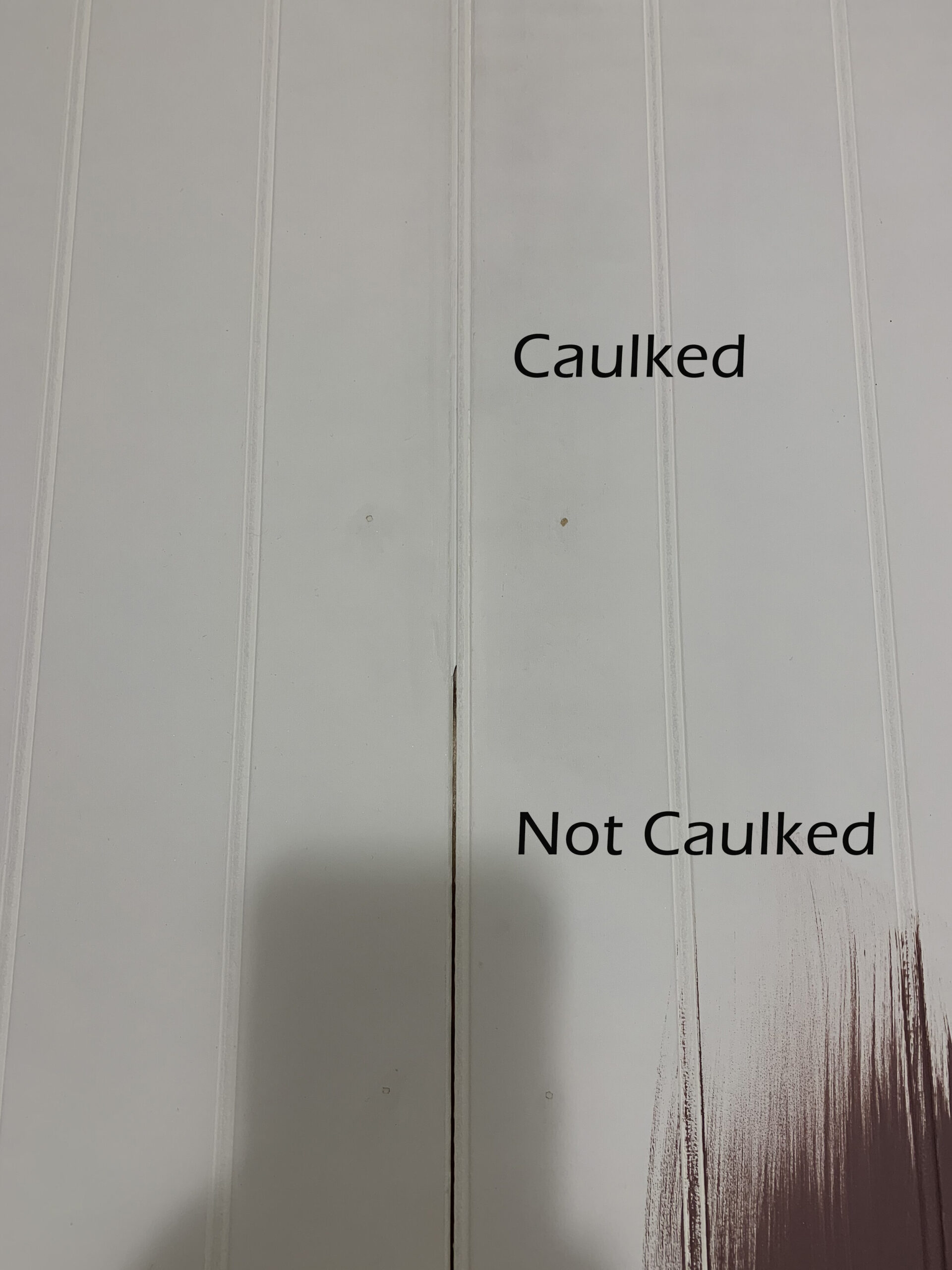 a seam between two peices of beadboard half caulked to show the difference