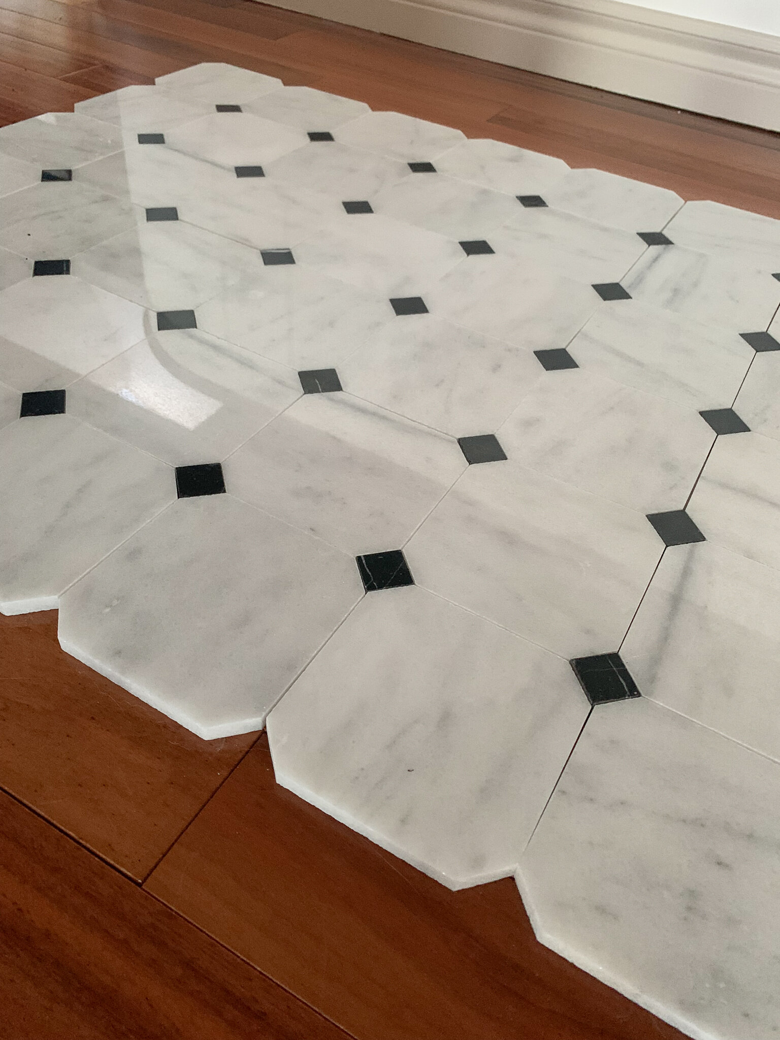 Close up of cut marble octagon and dot tile on an angle