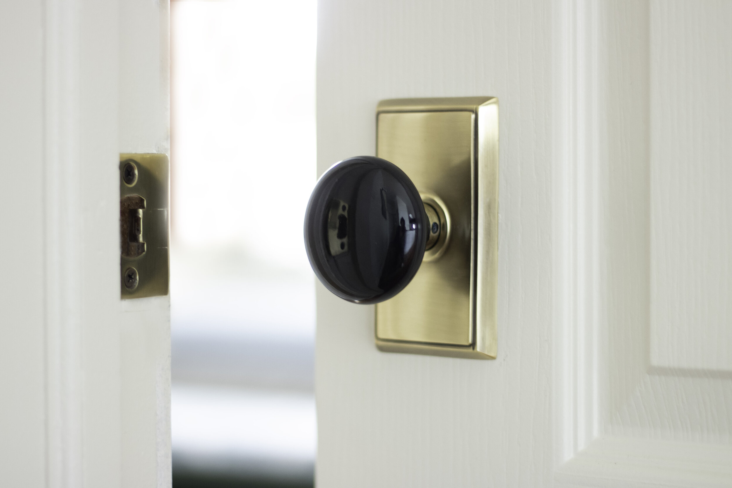 doorknob with antique brass back plate and black porcelain knob
