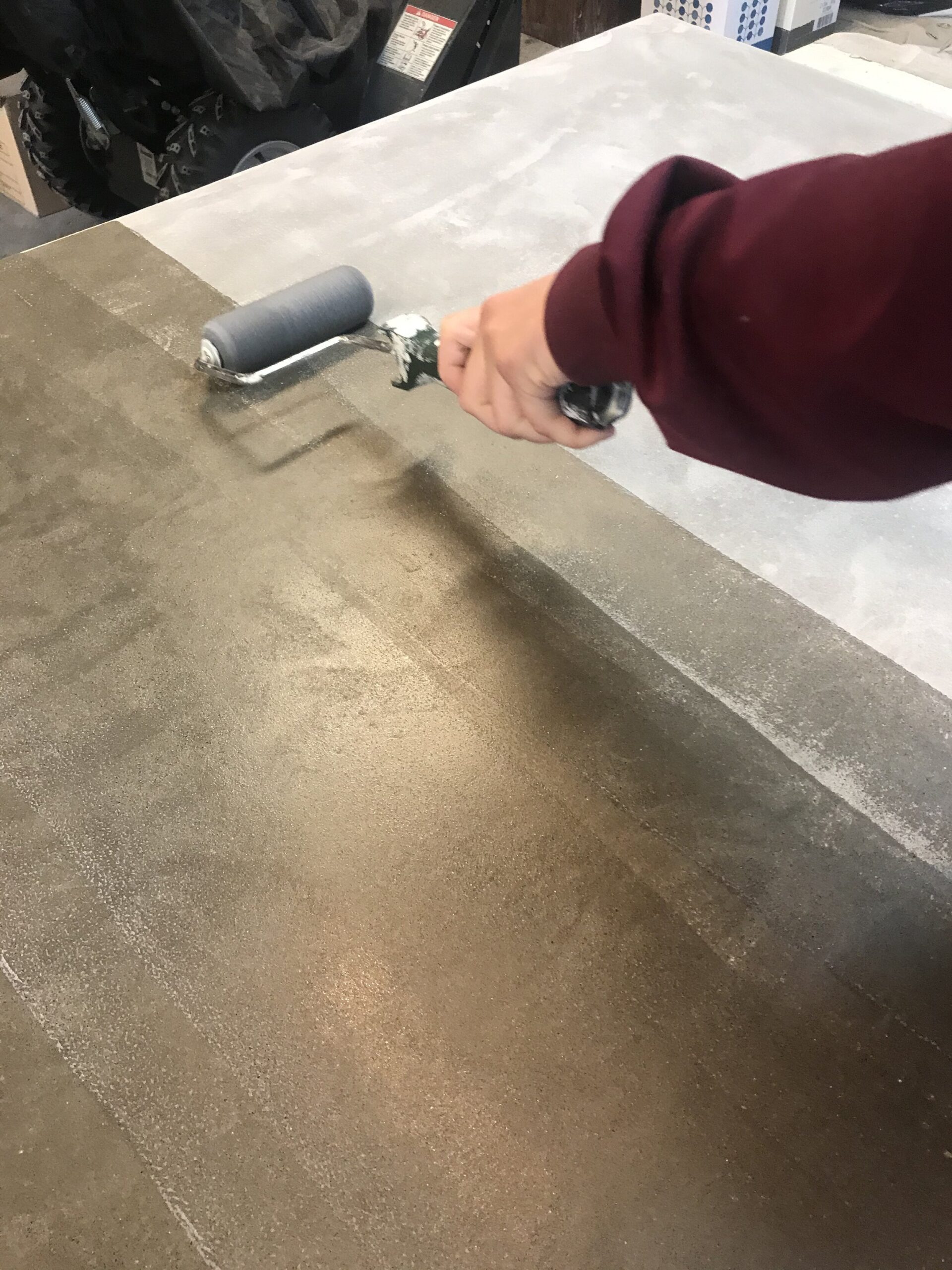 rolling sealer on a concrete table top
