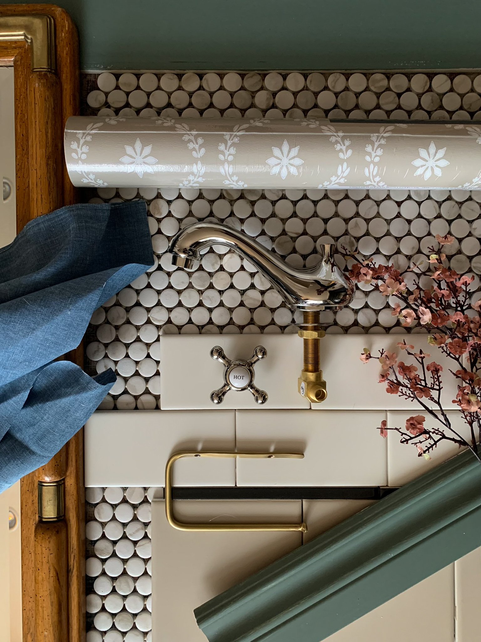 Bathroom moodboard flat lay including subway tile in three colours, brass fixtures, penny tile, wood mirror and green trim