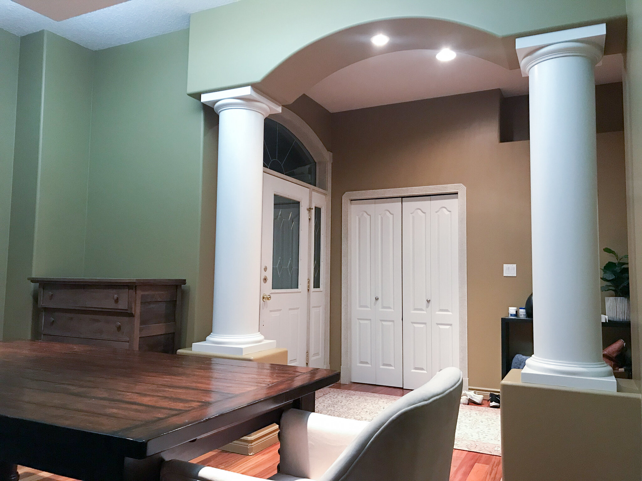 looking towards entry way through dinign room arched opening flanked by two large pillars