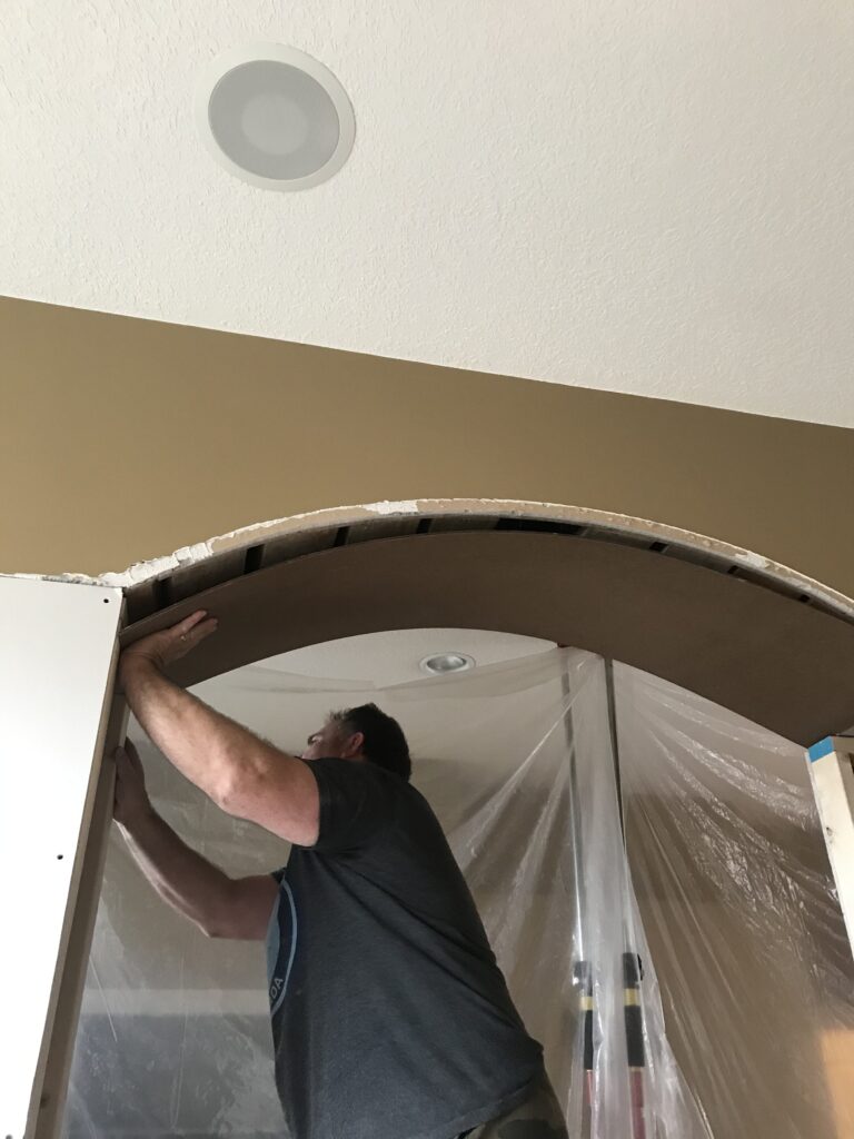 Bending a piece of hardboard over the underside of an arched opening