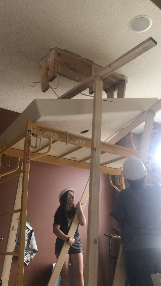 Lowering a larged drywalled box down from a ceiling onto a scaffold