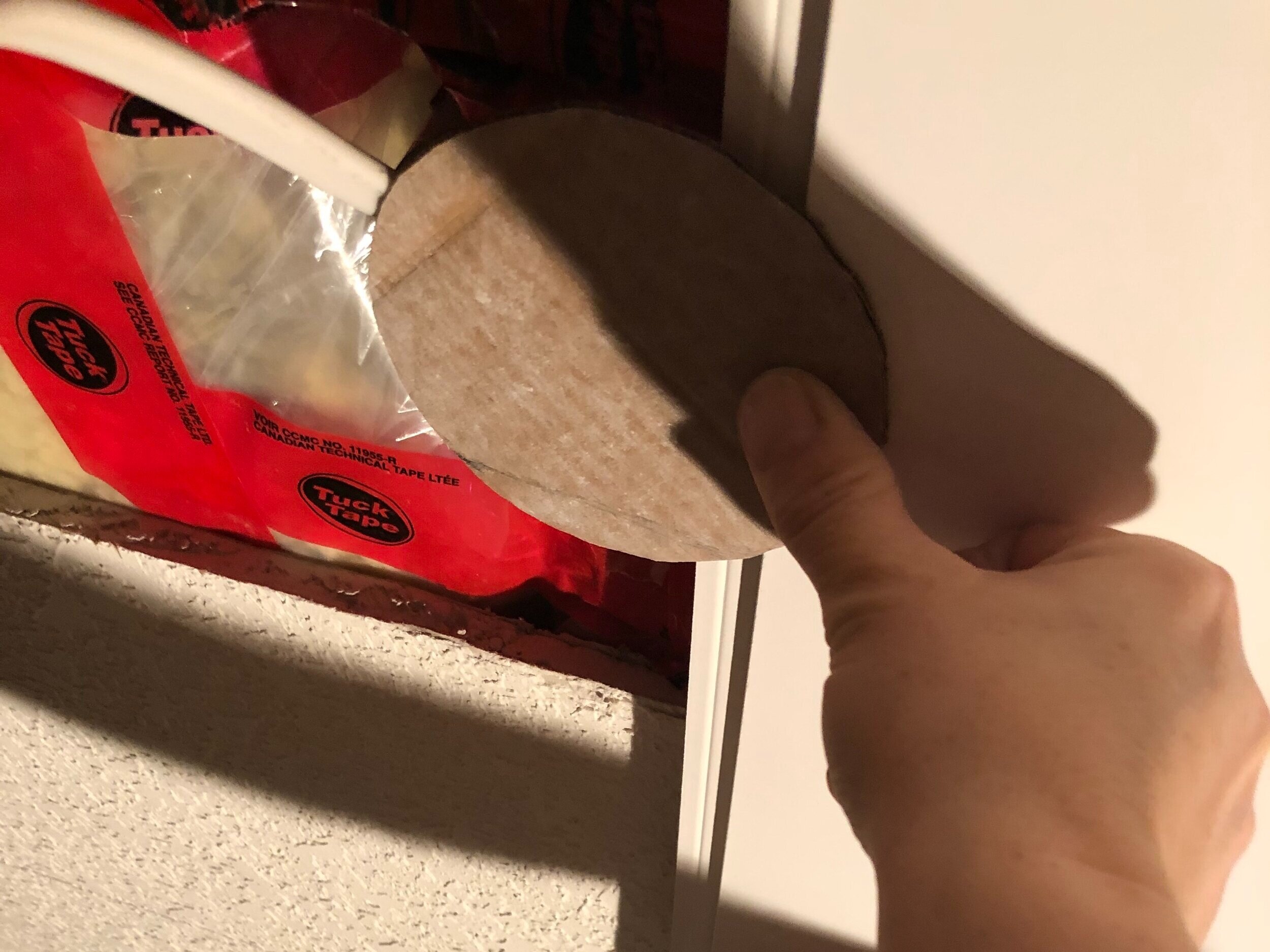 holding the cardboard template up to the board to mark a spot for a hole for a light