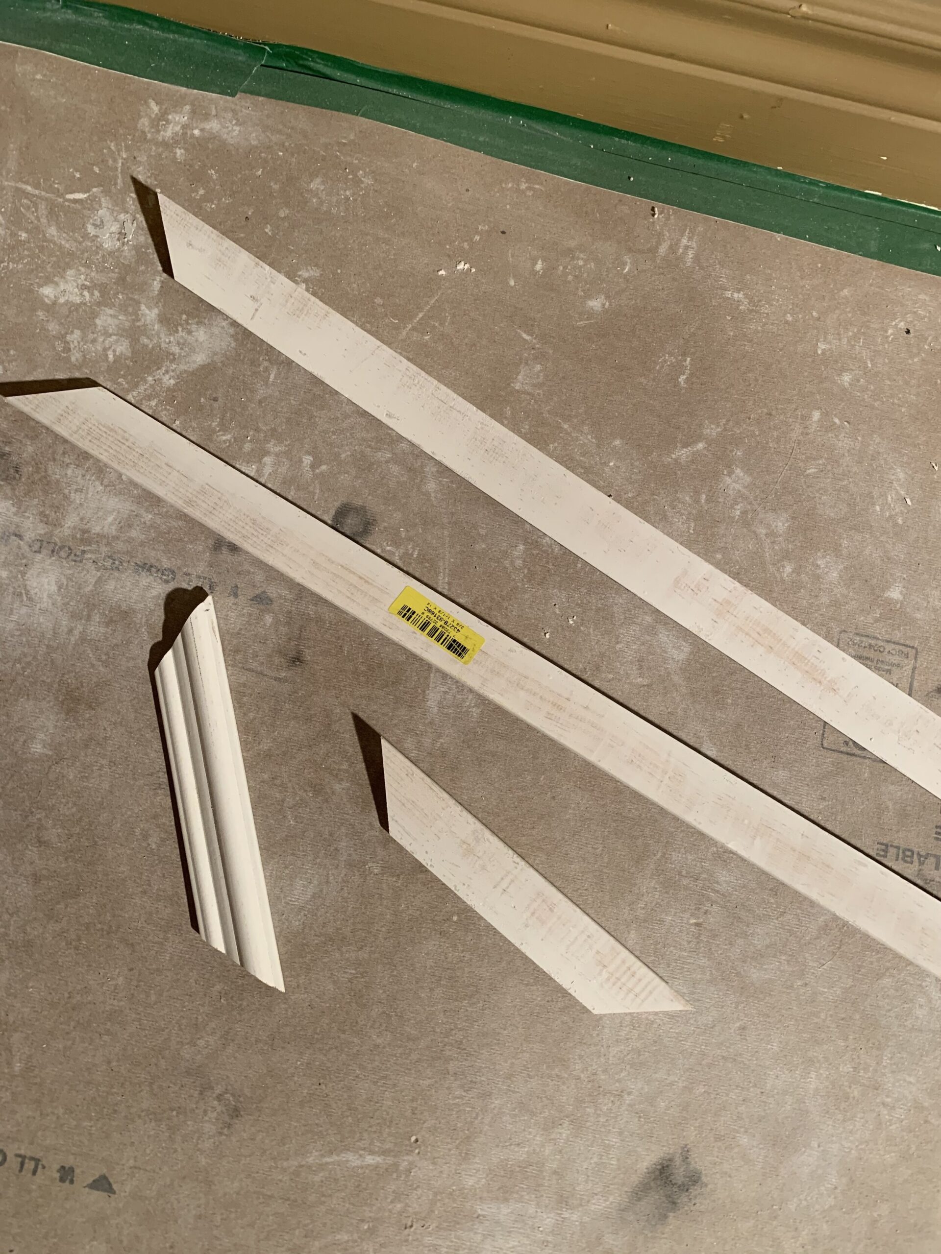four pieces of box trim moulding cut with mitred edges sitting on the floor