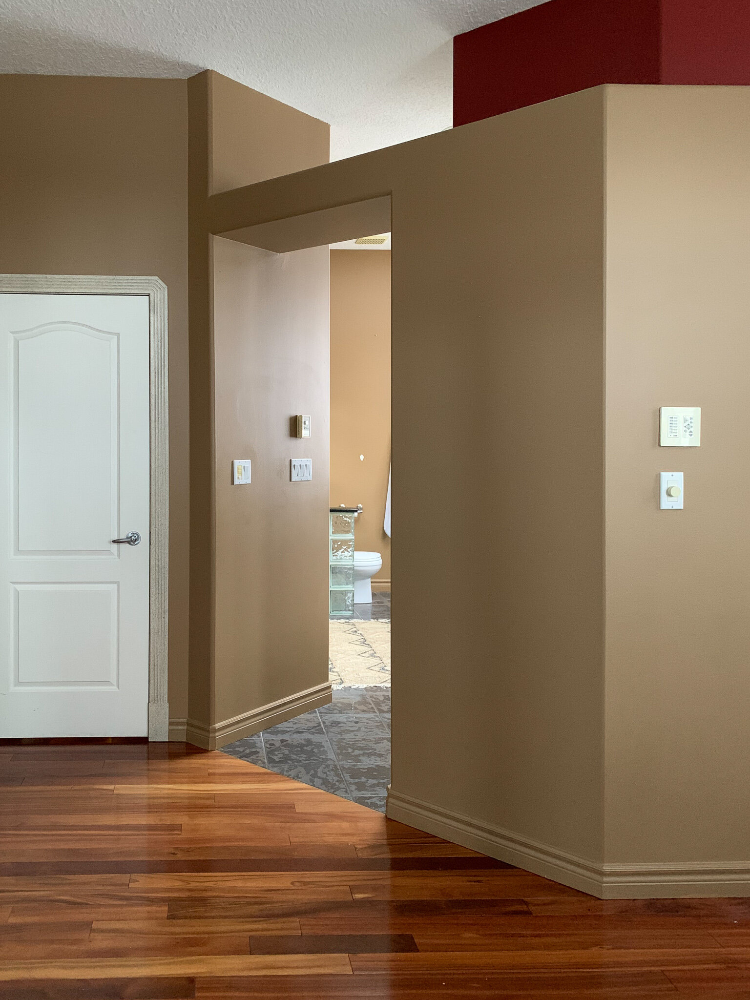 bedroom with opening into bathroom and no door and ledge above