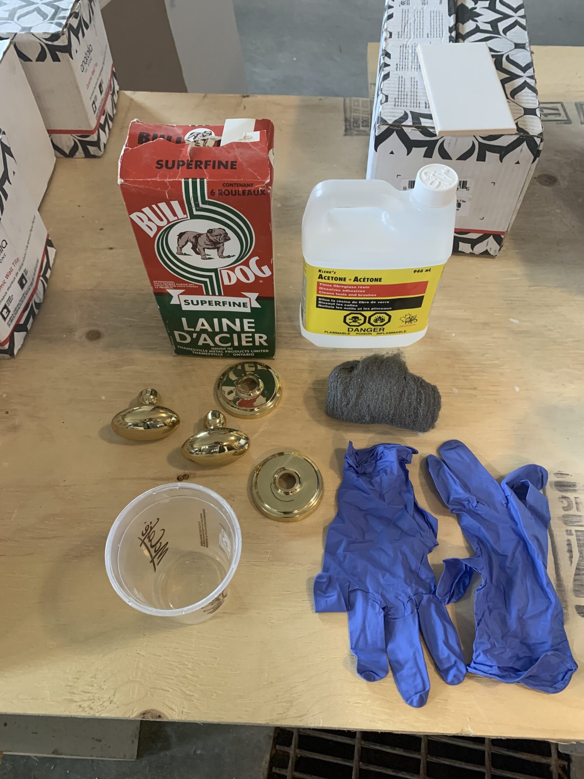 How to remove lacquer from brass? 
 Supplies used to remove laquer from brass including steel wool, acetone, and rubber gloves