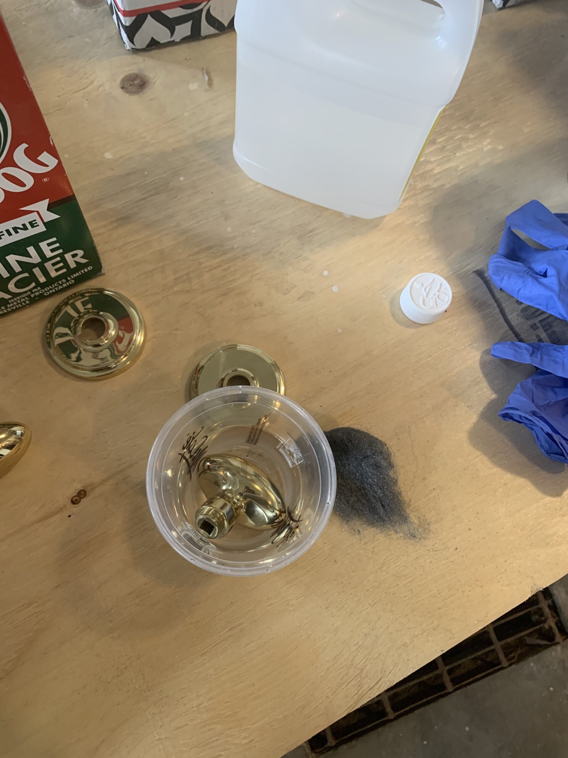 how to remove laquer from brass, start by soaking a piece of a brass door knob in a plastic cup with acetone to loosen the laquer in order to strip the brass