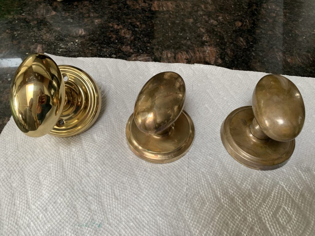 three doorknobs showing various levels of tarnish, doorknob was stripped of lacquer and then aged using vinegar