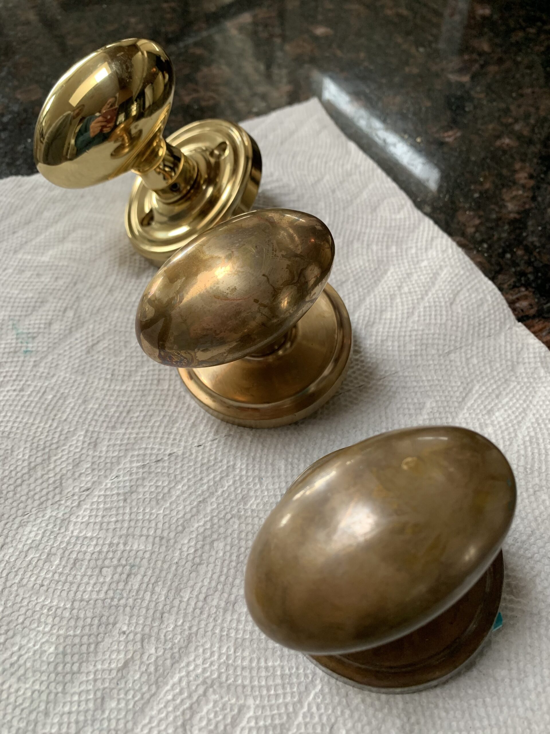 three doorknobs with varying levels of aging or tarnish. Door handles were removed of lacquer and then aged using vinegar