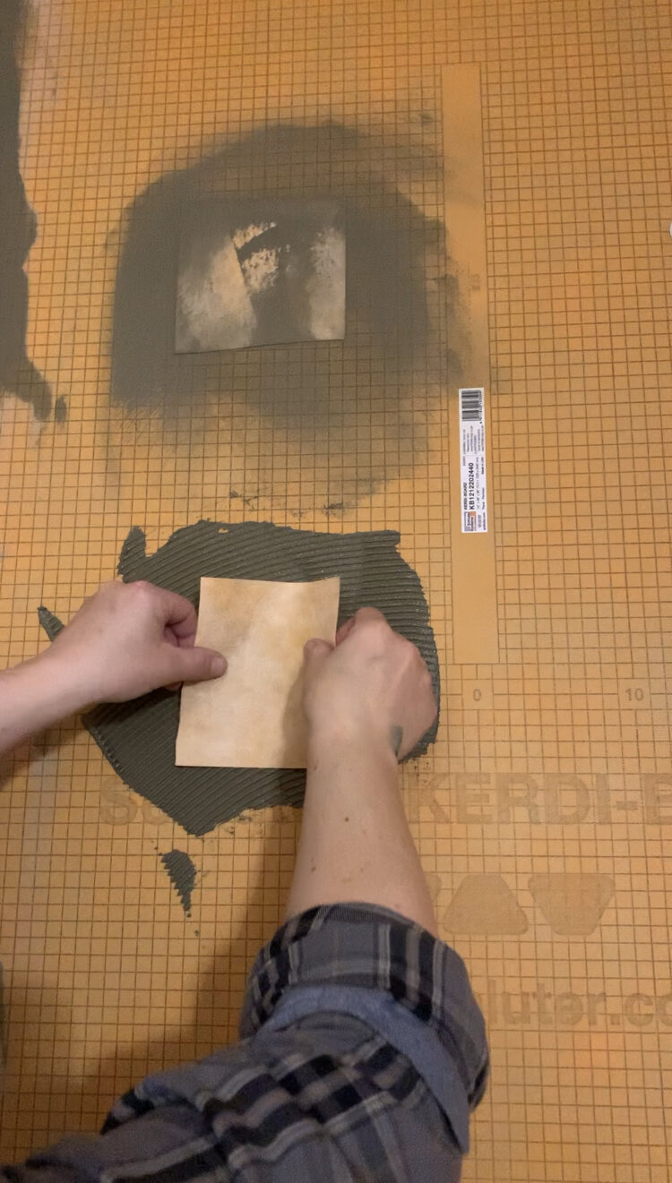 small squares of kerdi band cut into a square being applied over the screw holes