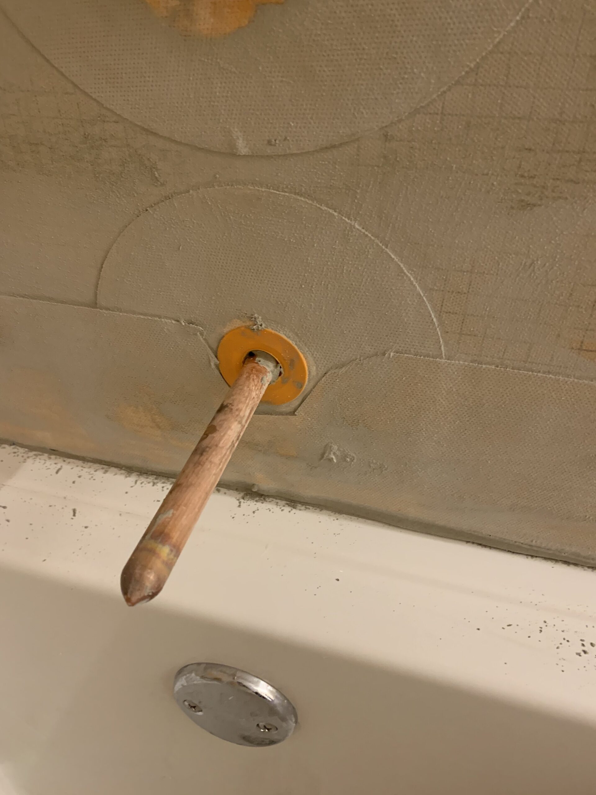 Tub spout with seal installed around it and mortared in place