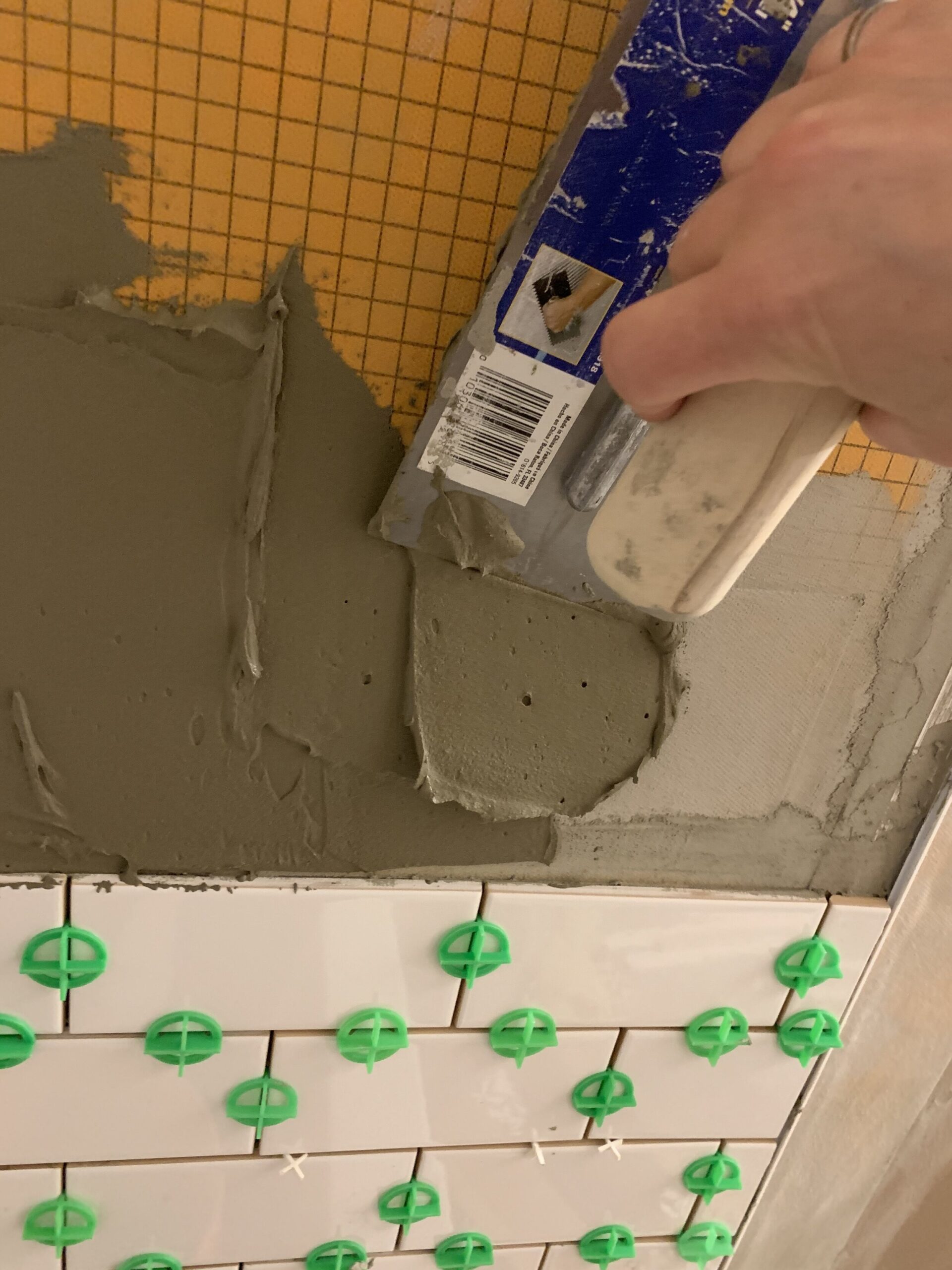 Spreading mortar using the flat side of a trowel