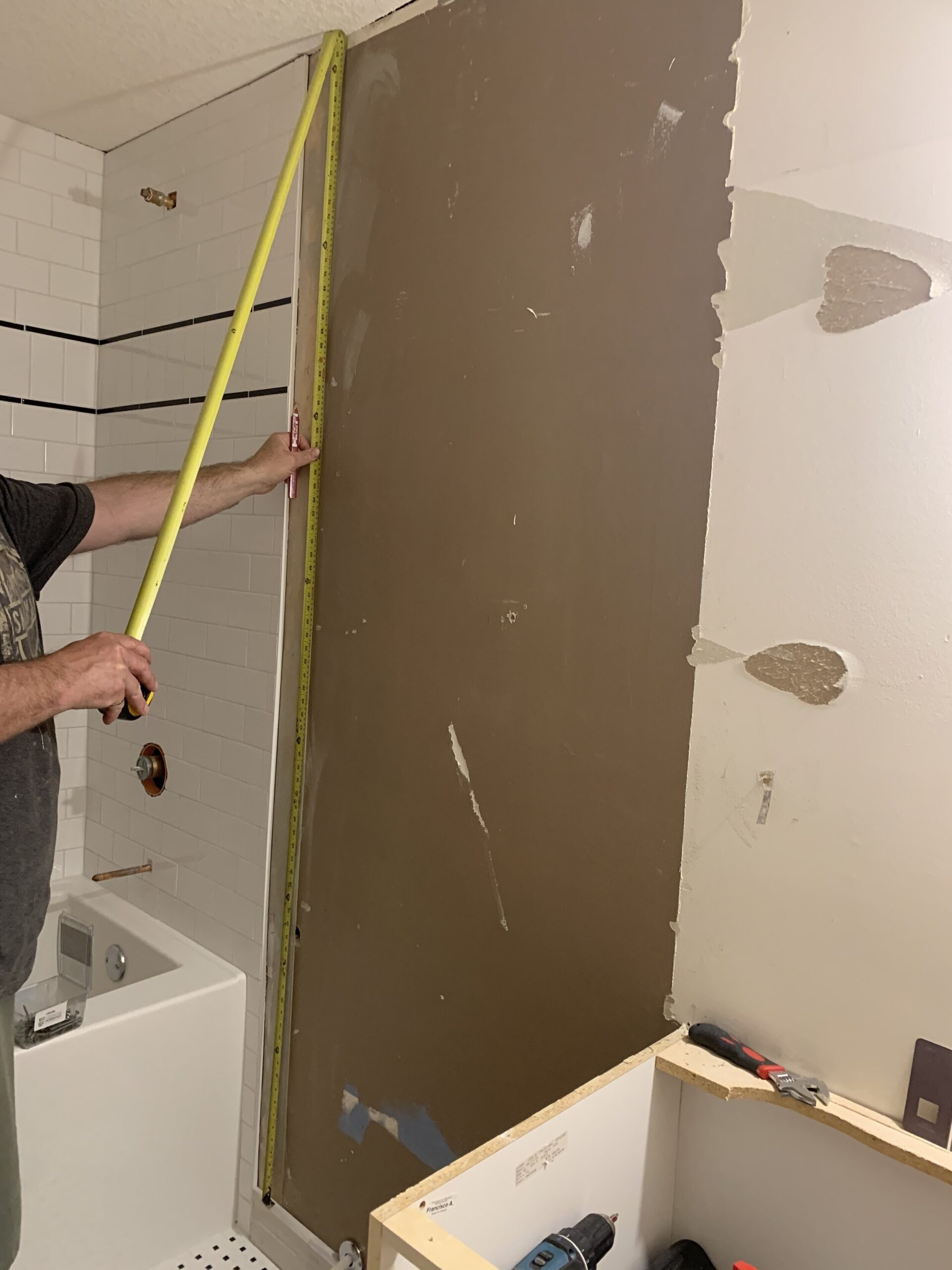 measuring the wall where the beadboard panelling will go prior to installation