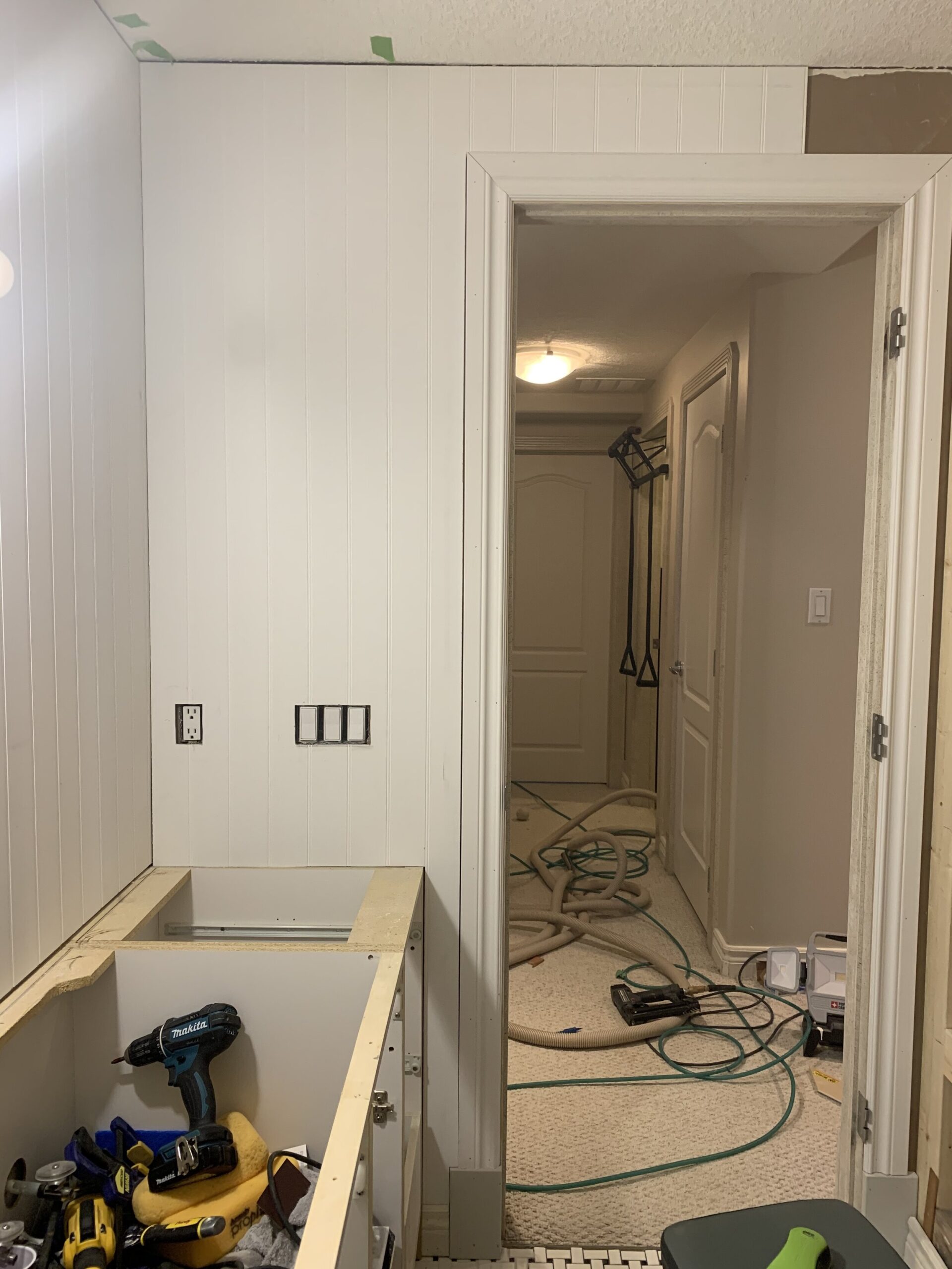 installing beadboard panelling that was cut out around door and vanity in place and fitting well