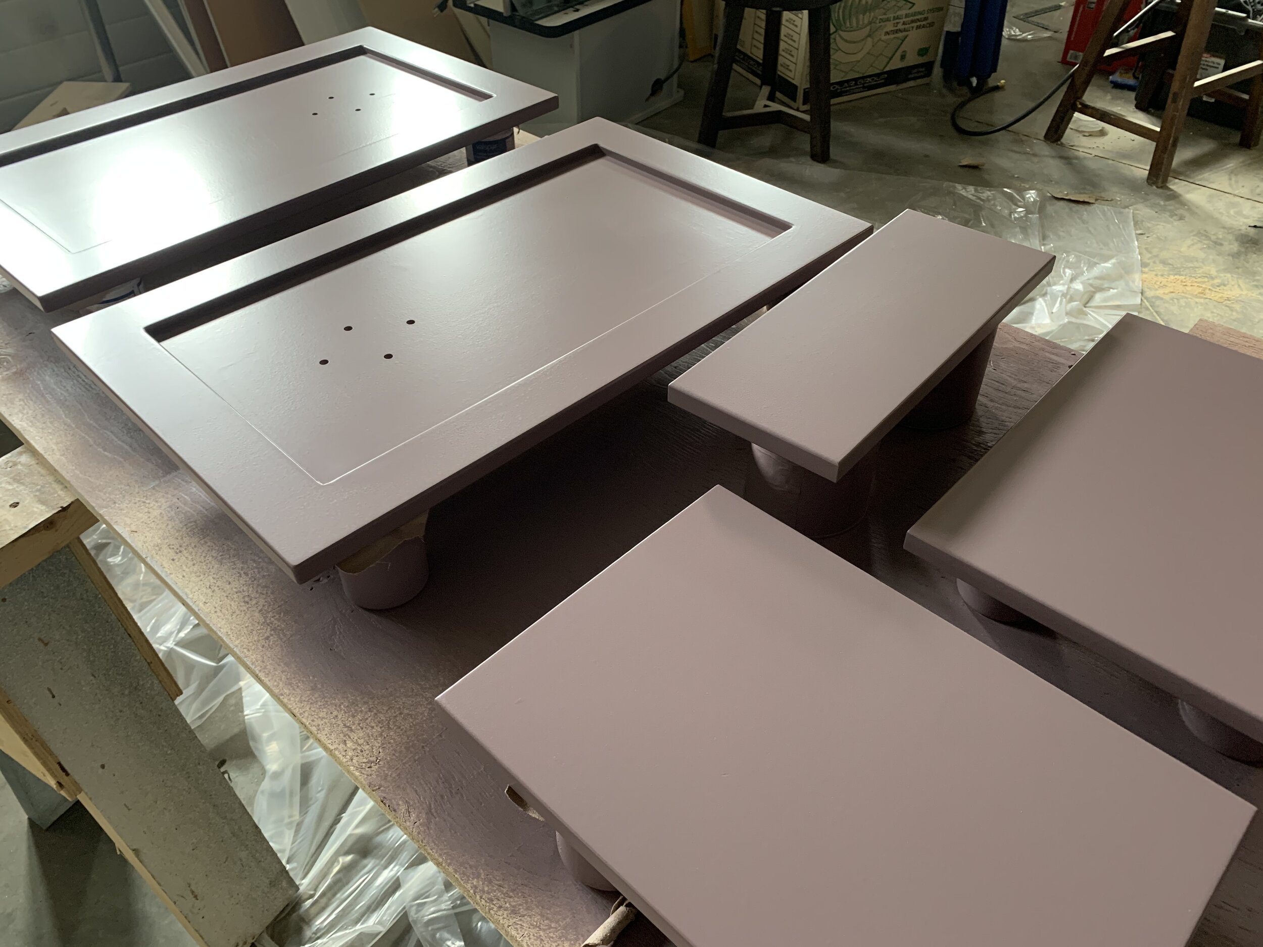 Cabinet doors layed out on a table, freshly spray painted purple