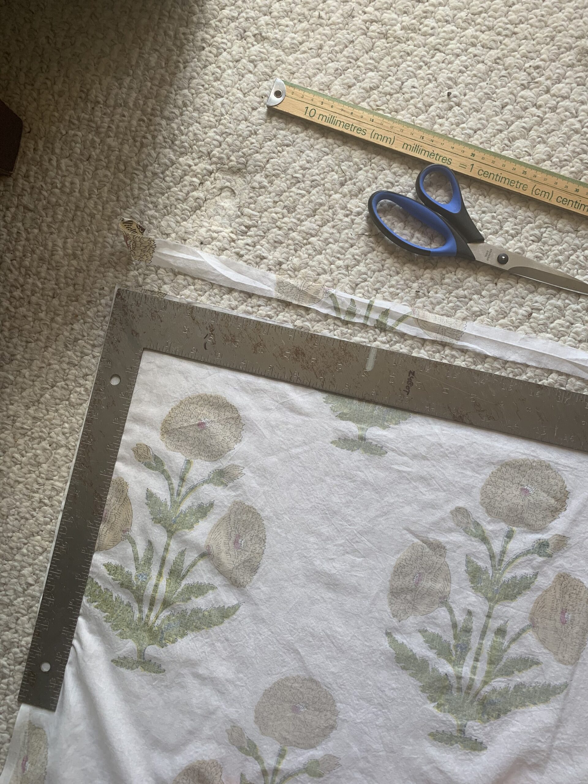 using a square to square off the end of floral fabric,