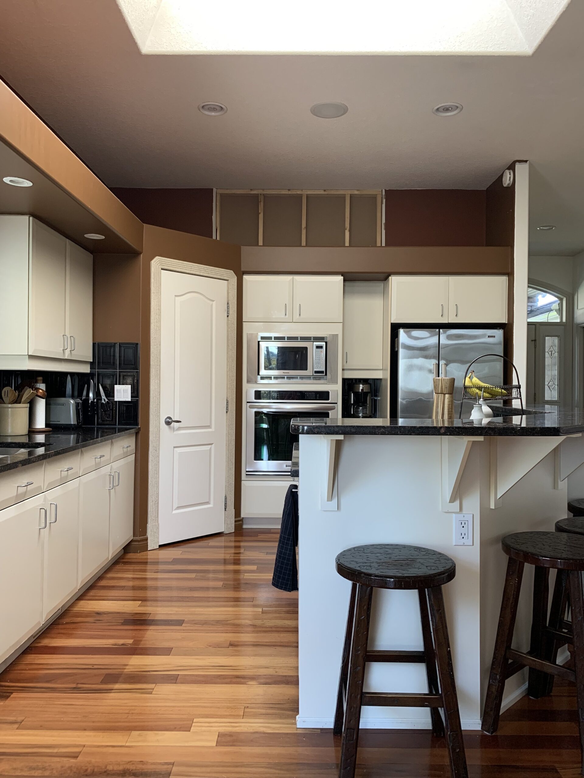 90's kitchen with burgendy walls, a soffit, built in oven with corner pantry before photo