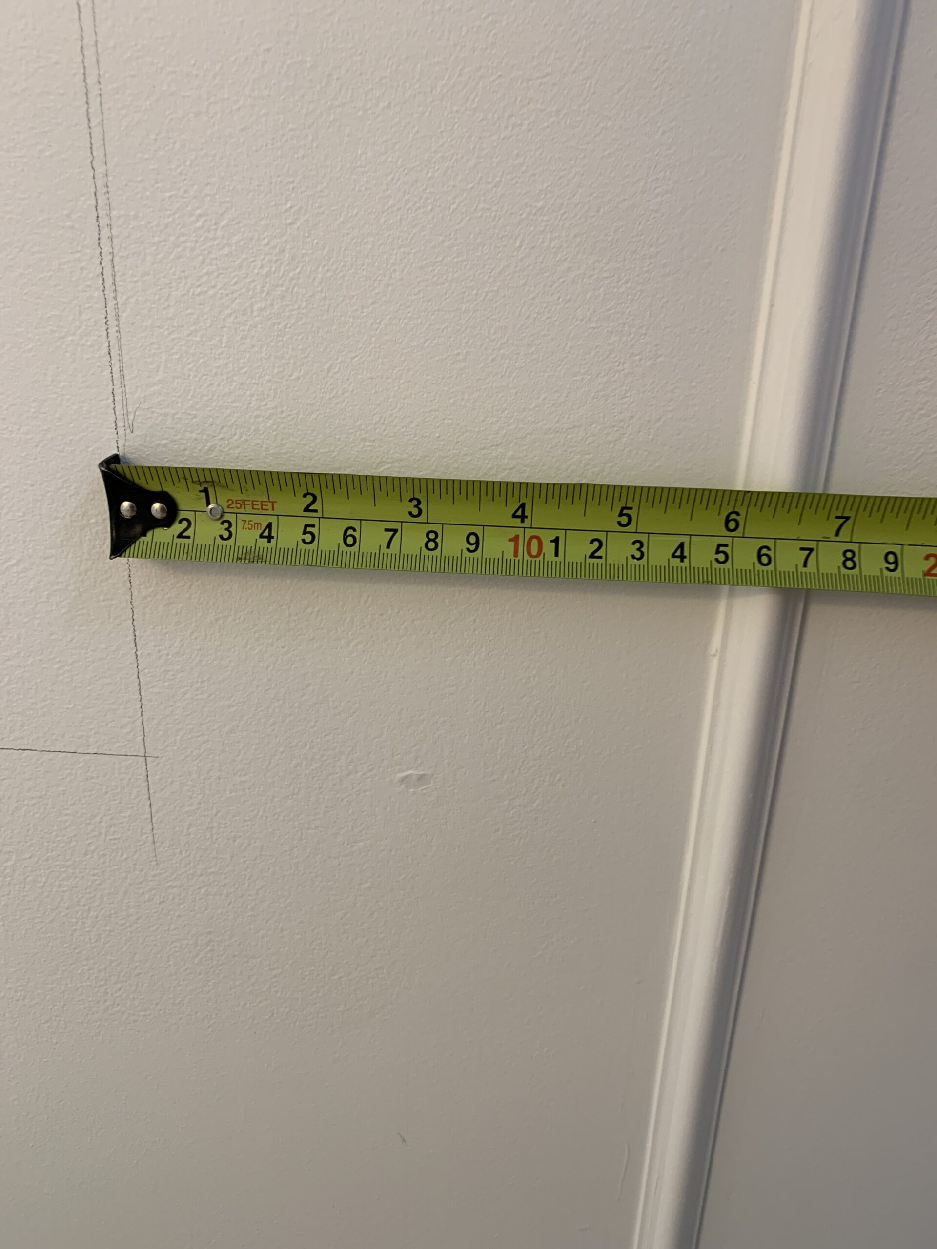 a tape measure showing 6 inches between trim and pencil mark