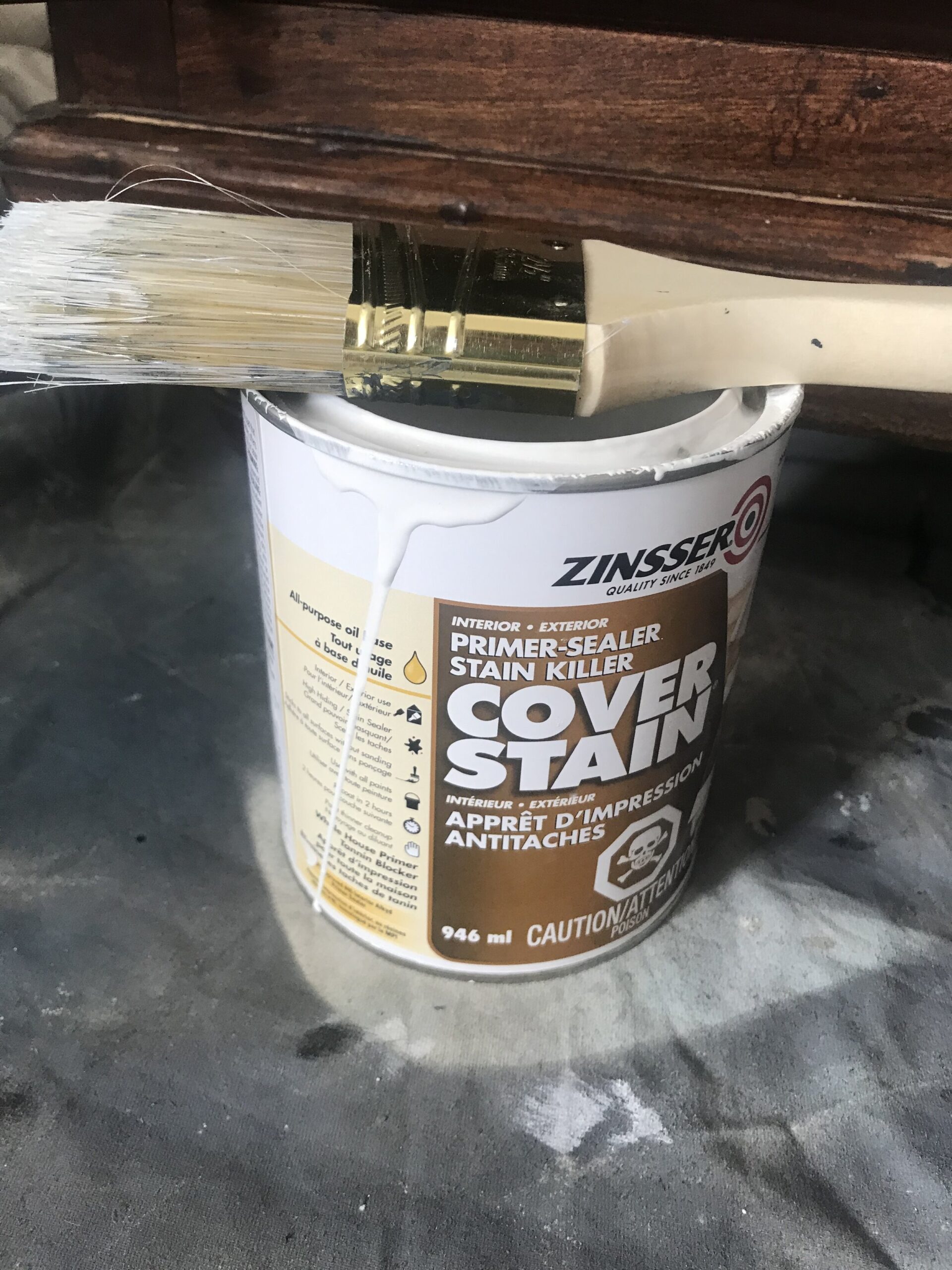 Can of oil based zinsser cover stain open with a paint brush on top