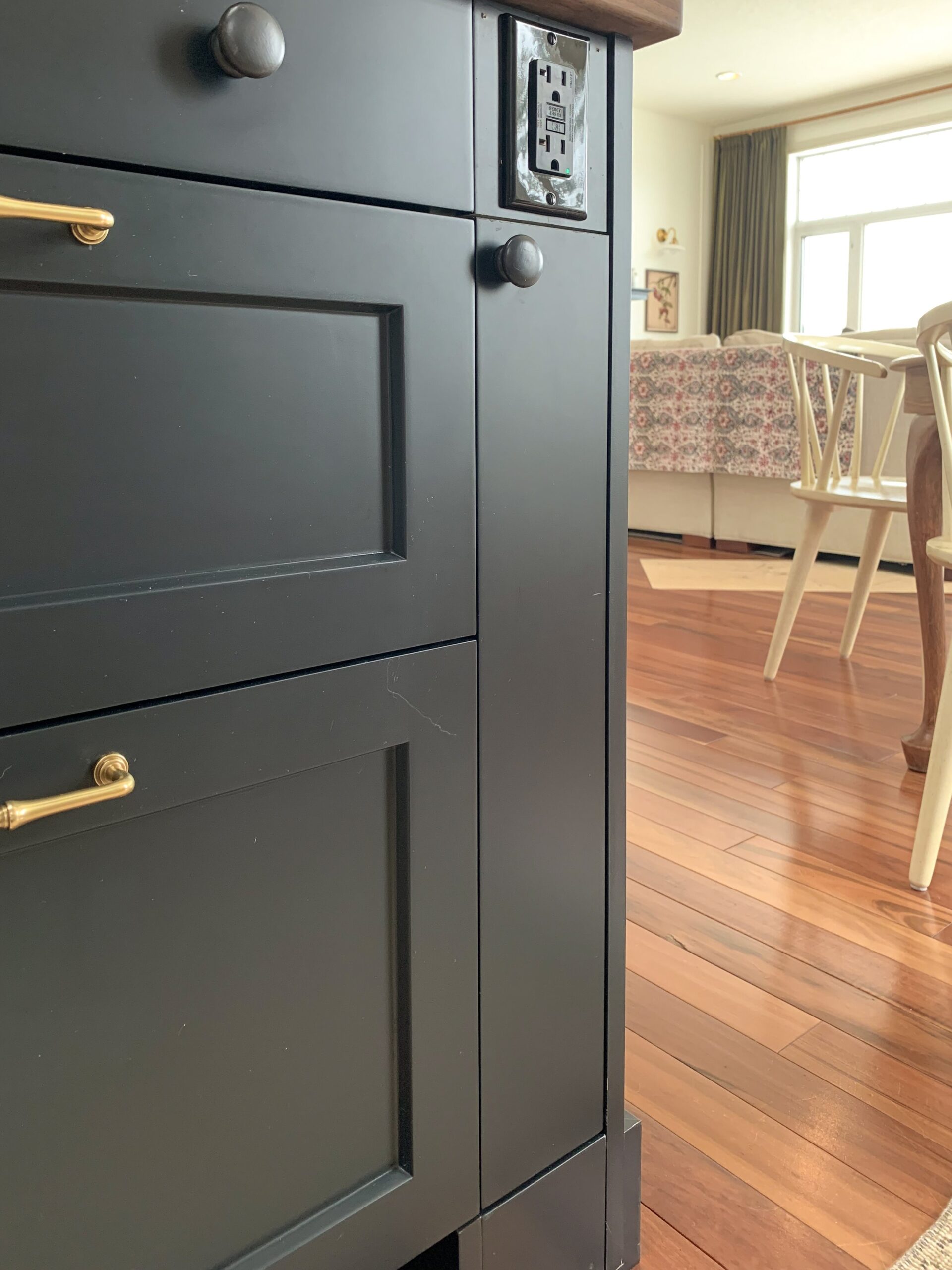 Skinny cabinet installed at the end of an island with an outlet above