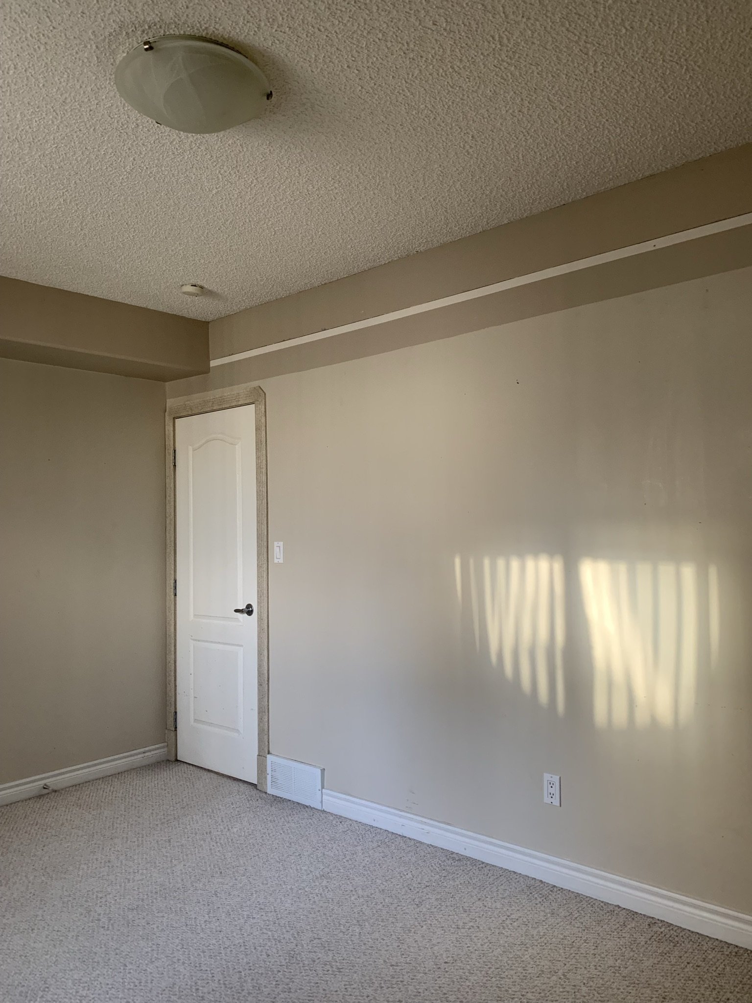 empty bedroom with beige walls and white trim