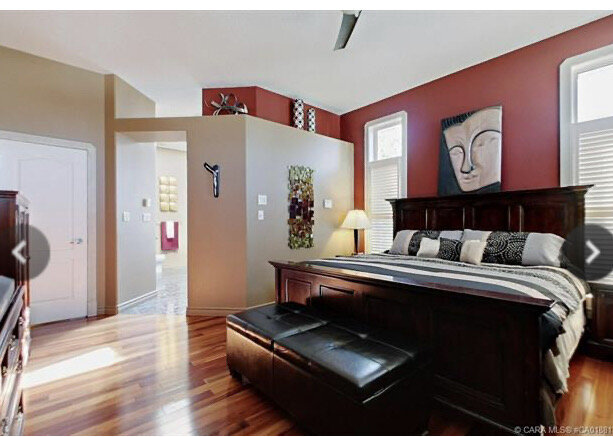 real estate listing showing brown and red walls, opening into bathroom with ledge above, brown furniture