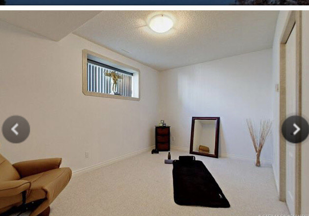 Bedroom with white walls, popcorn ceiling, yoga mat in floor and minimal furniture