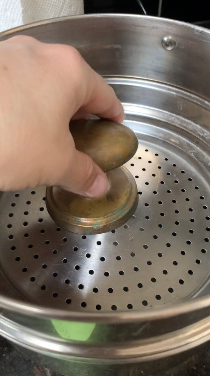 brass doorknob being placed inside a double boiler