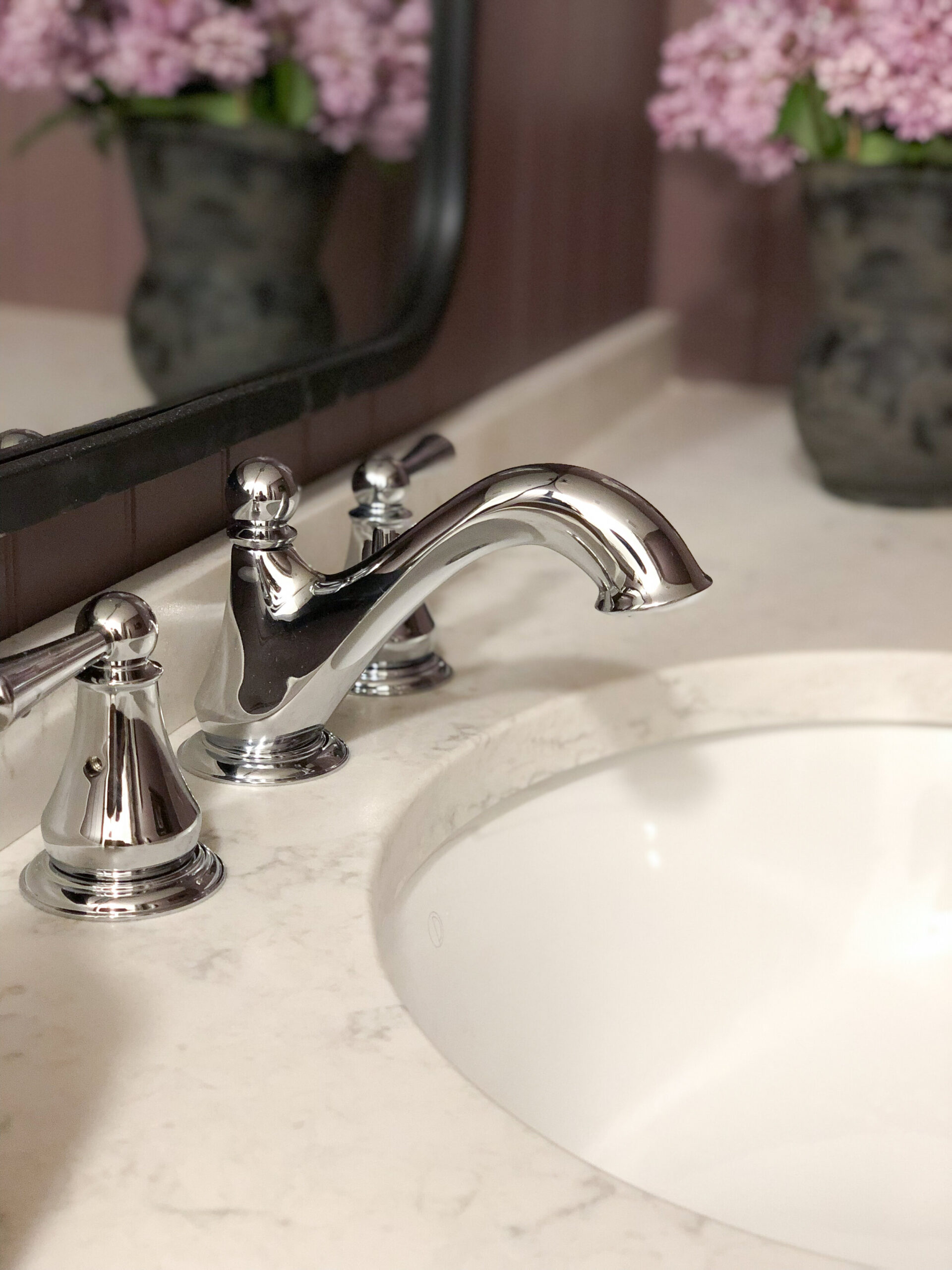 close up of vintage style chrome fixtures from Delta on a quartz counter with white undermount sink