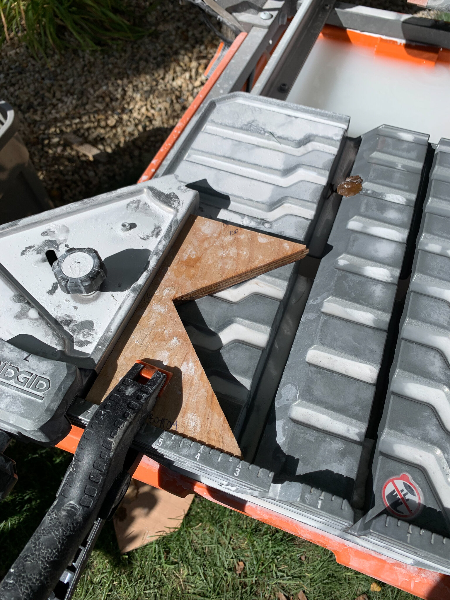 Wood jig clamped to wet tile saw