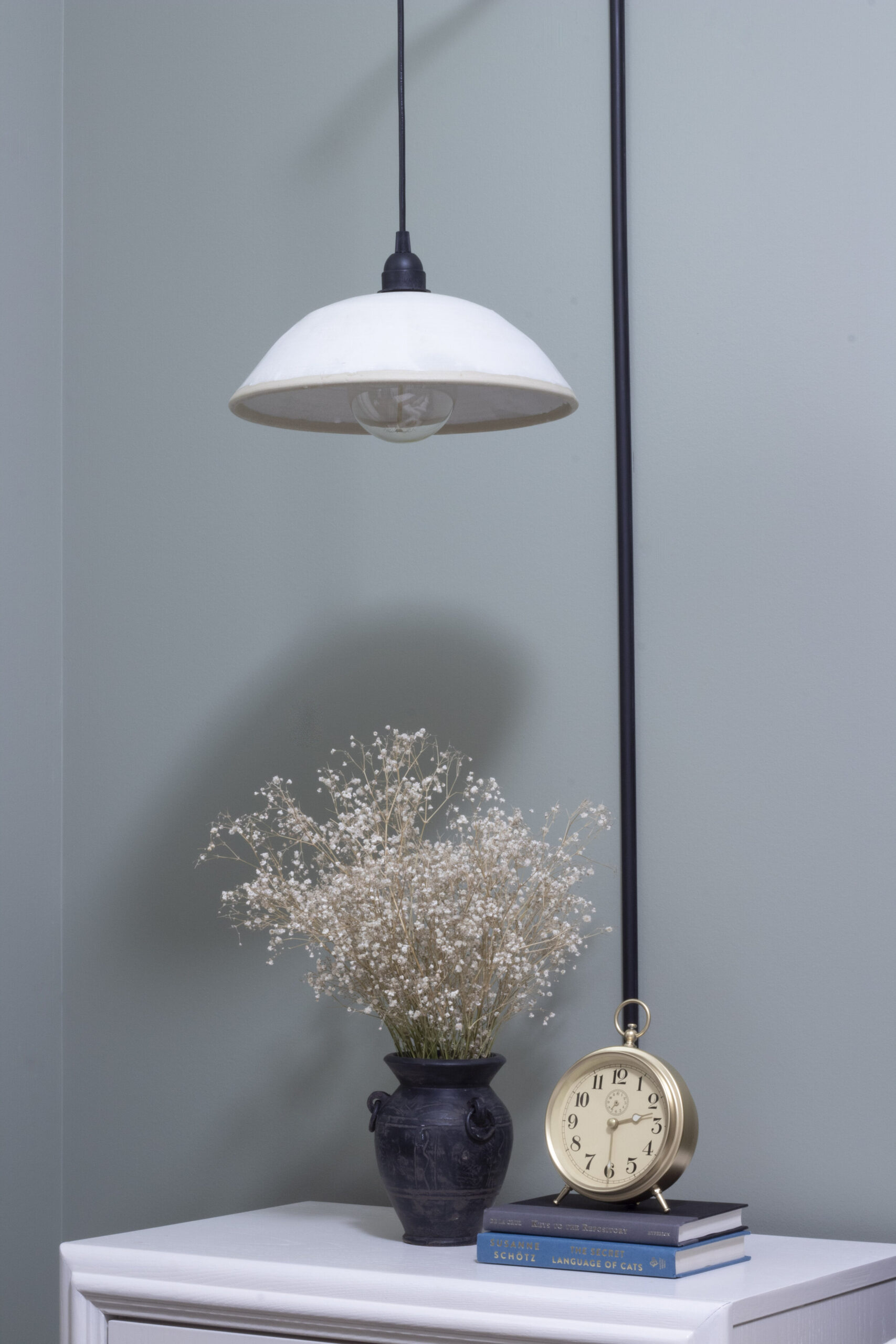 ceramic pendant hanging from a wall bracket in a green room