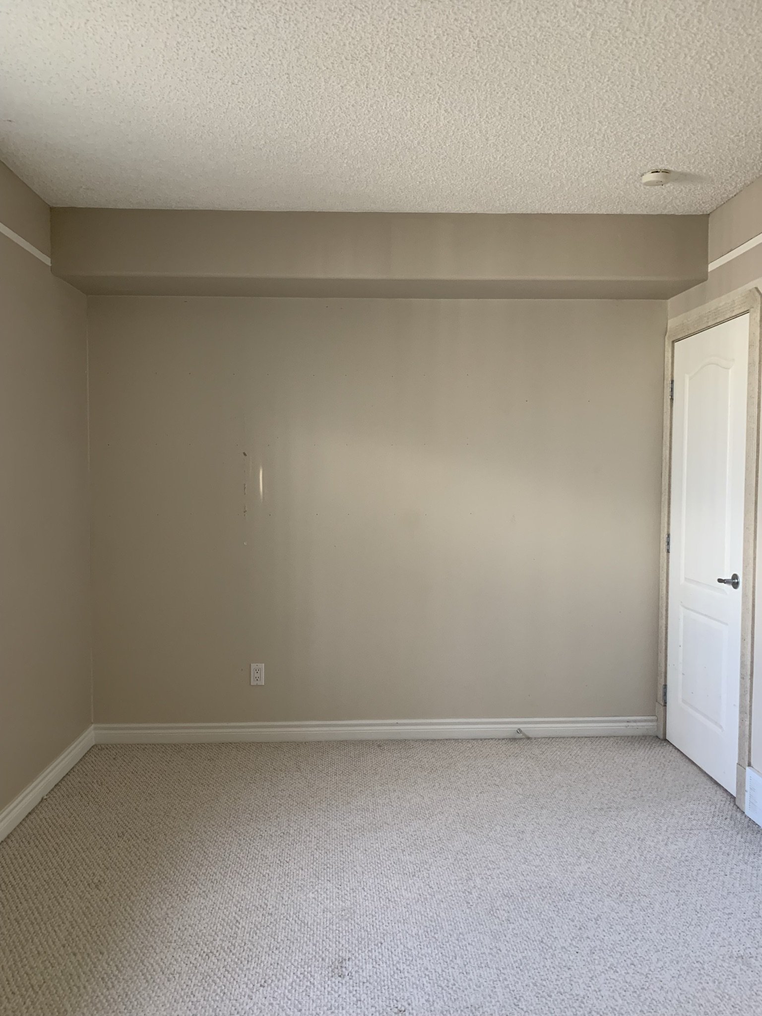 empty bedroom with white trim and beige walls