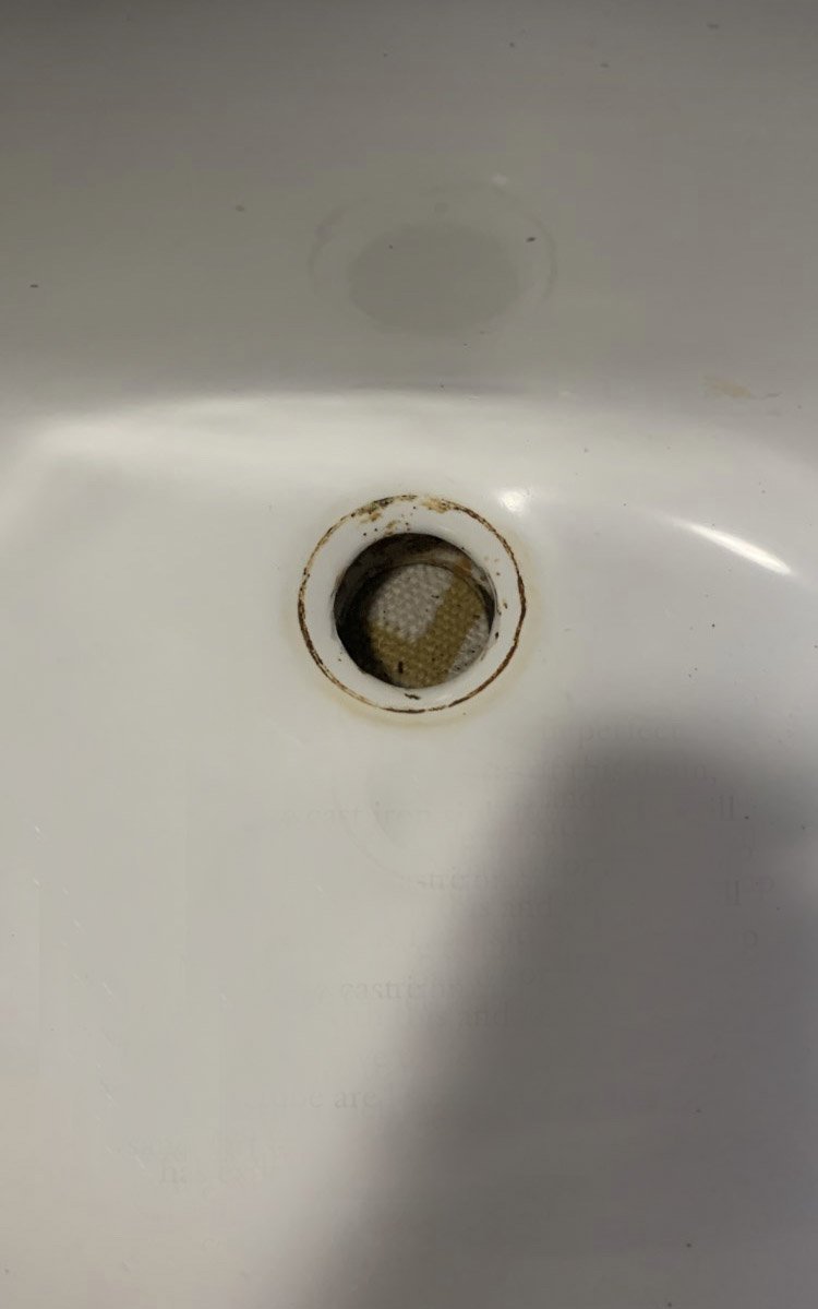 Rust stain around the drain on a cast iron sink