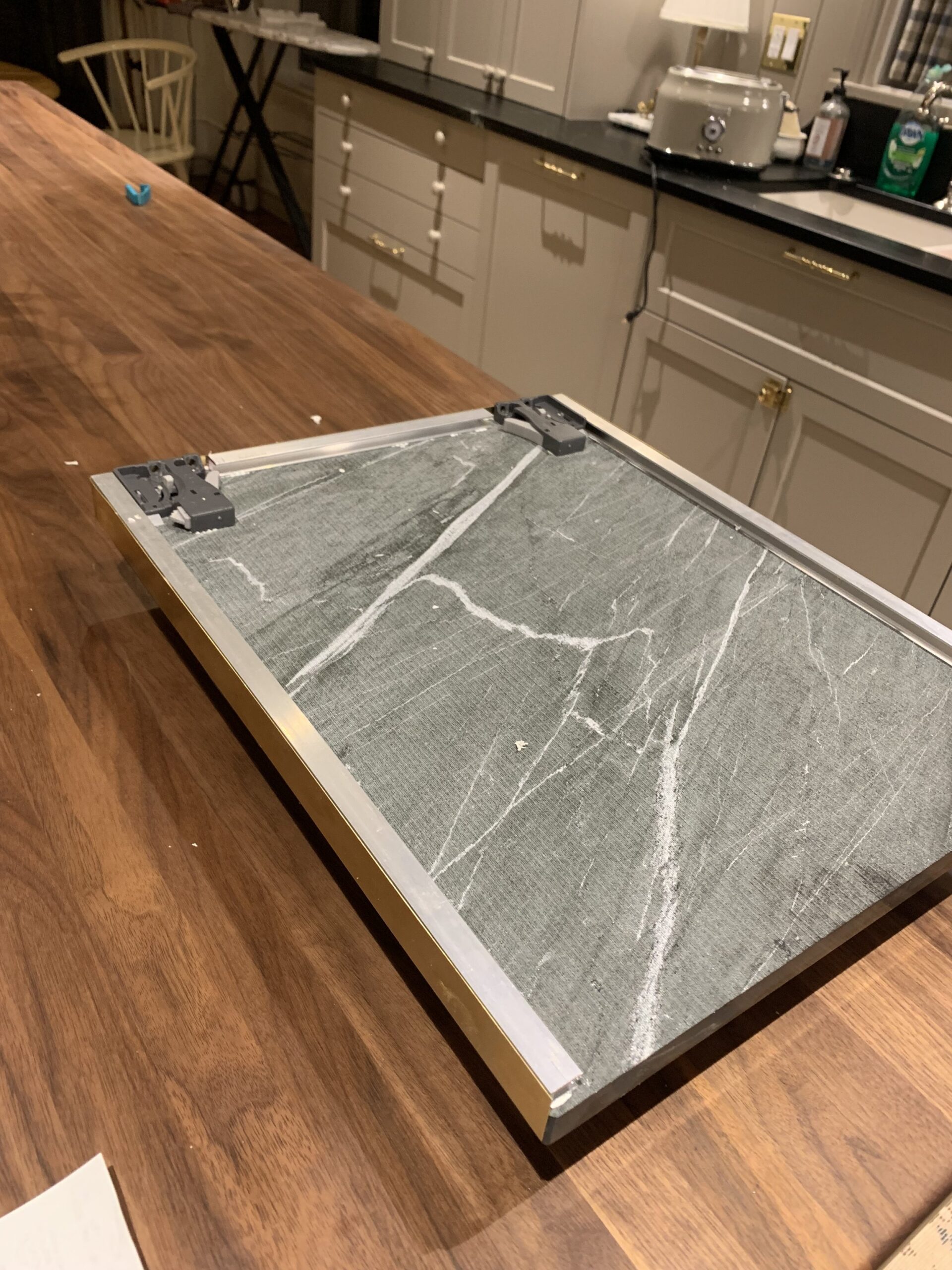 Underside of stone shelf with aluminum channels added and drawer slide mechanism