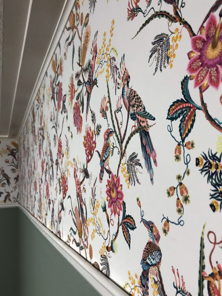 milton and king floral and fauna wallpaper with bright colours installed above a picture rail and below crown moulding