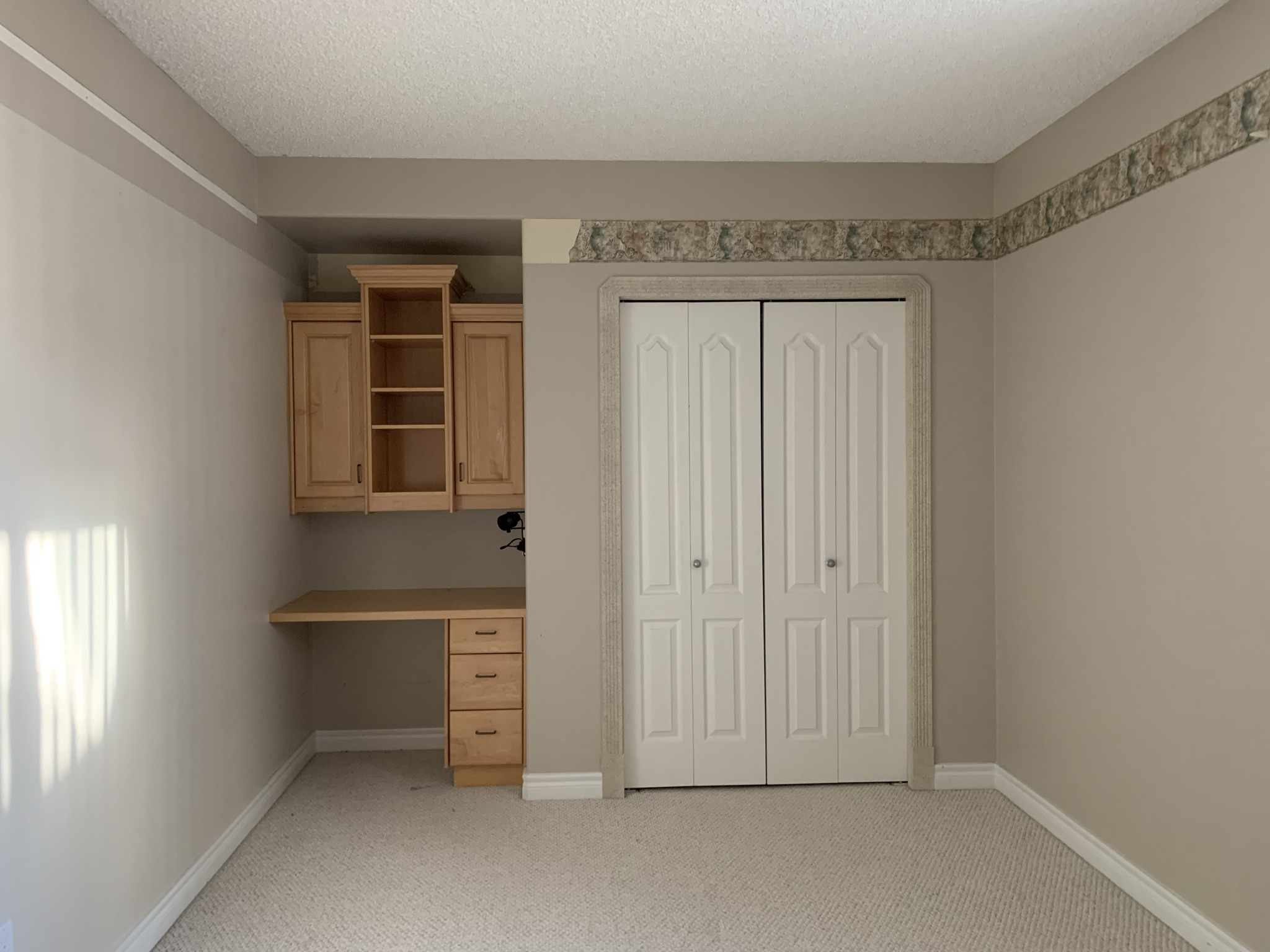 wall showing built in maple desk and closet