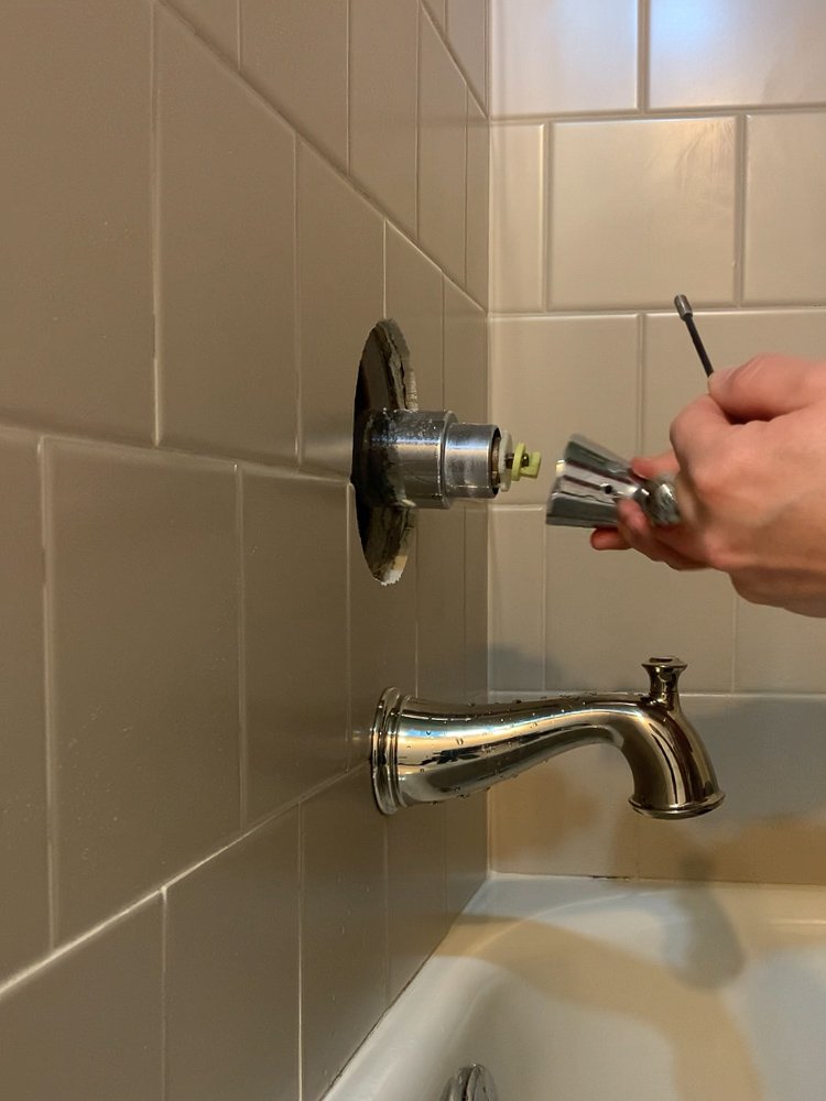 Removing the old handle for the tub using an allen key