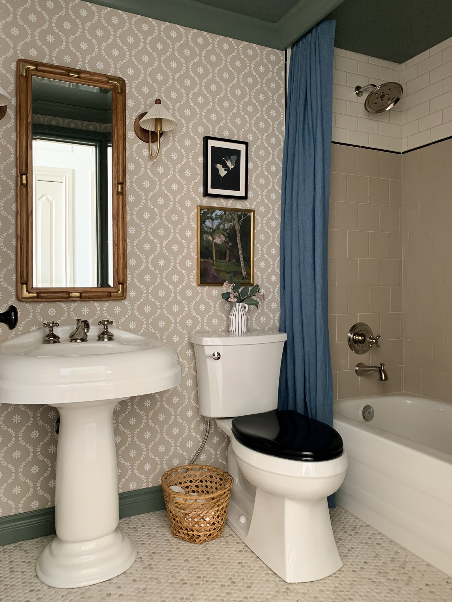 Blue linen shower curtain in beige bathroom with subway tile and floral wallpaper