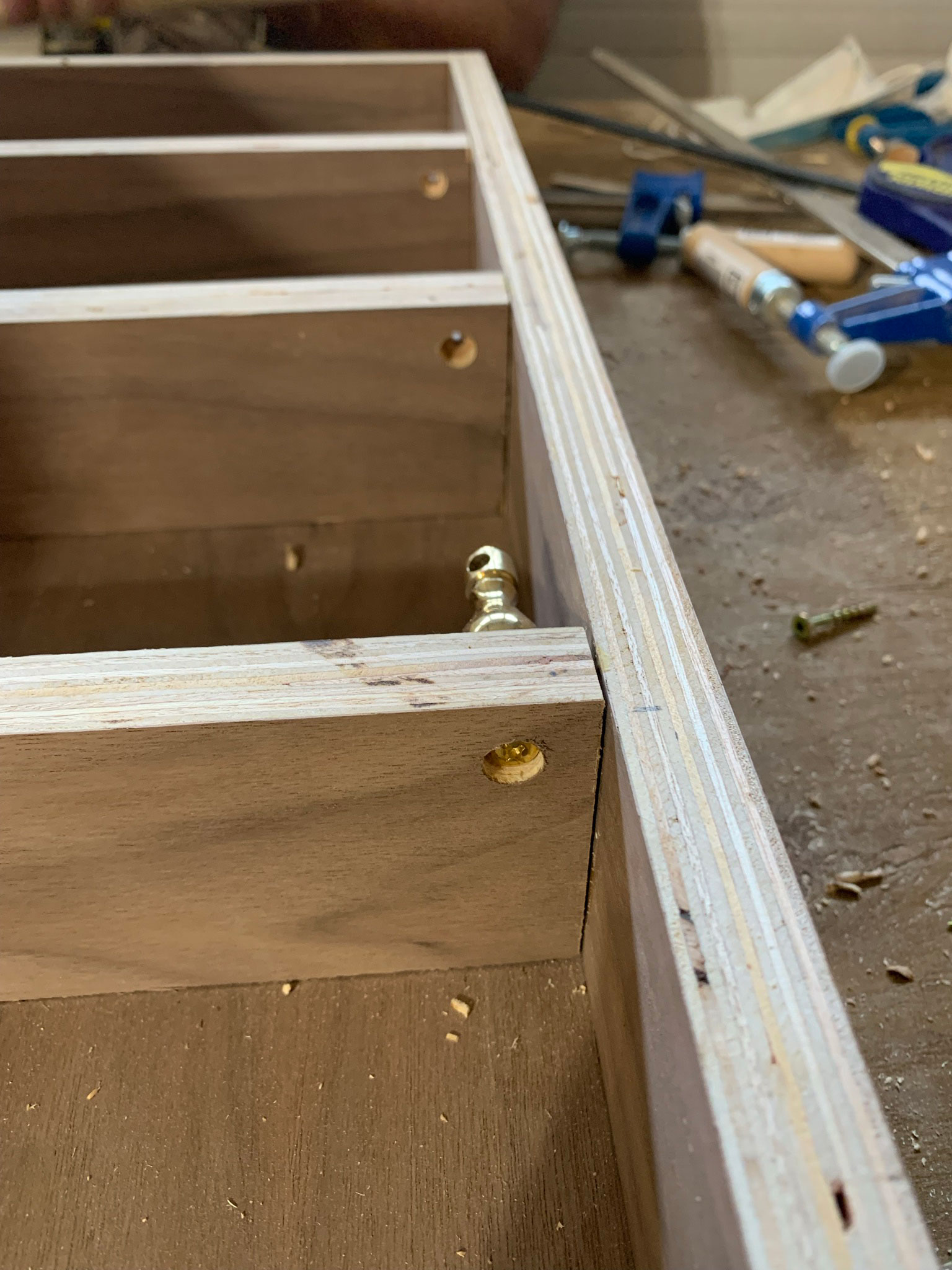 Bottom of shelf showing how screw holes were drilled out to allow screws to sit inset into shelf bottom