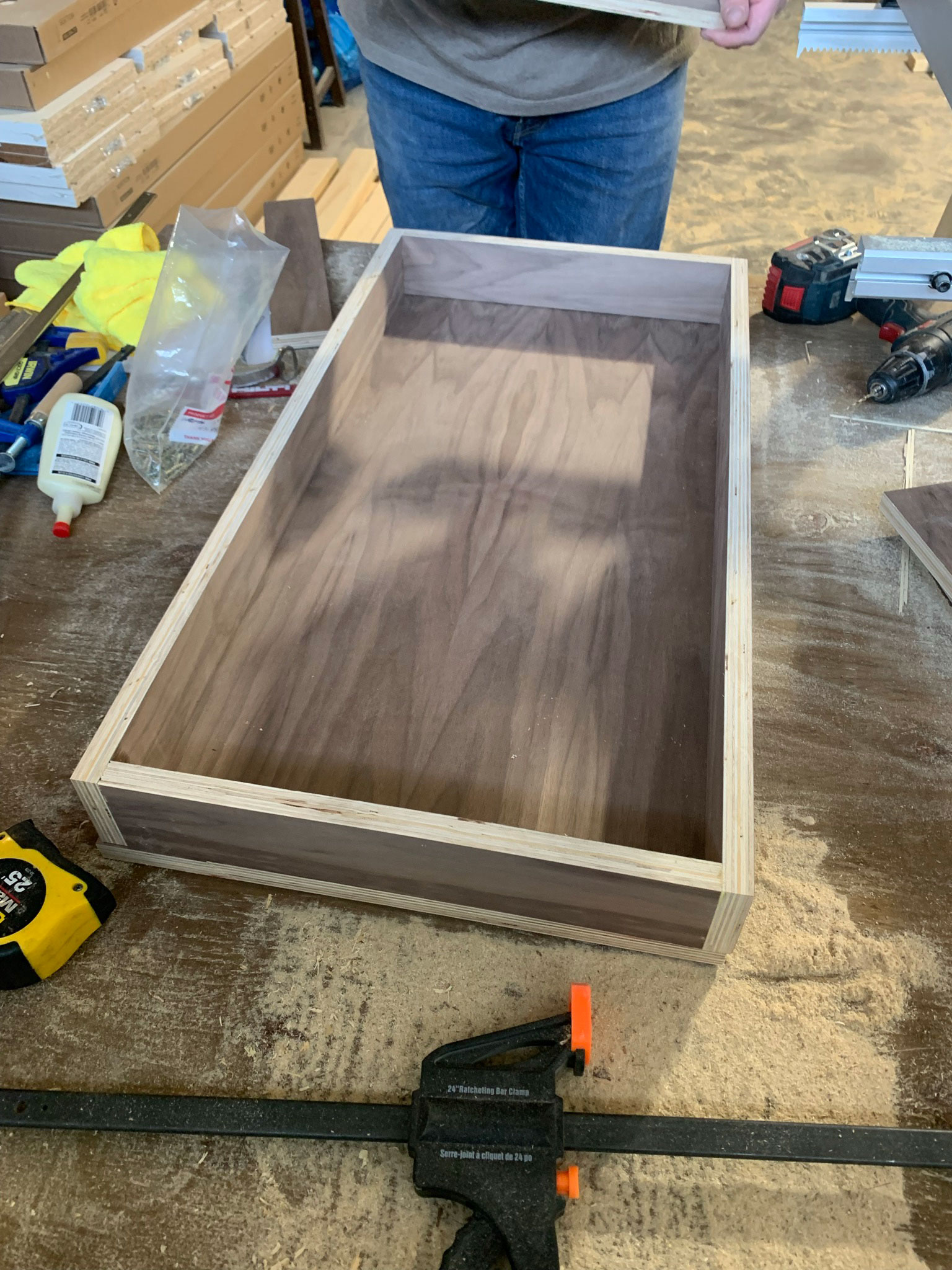 Plywood square cut out with pieces sitting on top for sides and back, making a shallow walnut plywood box