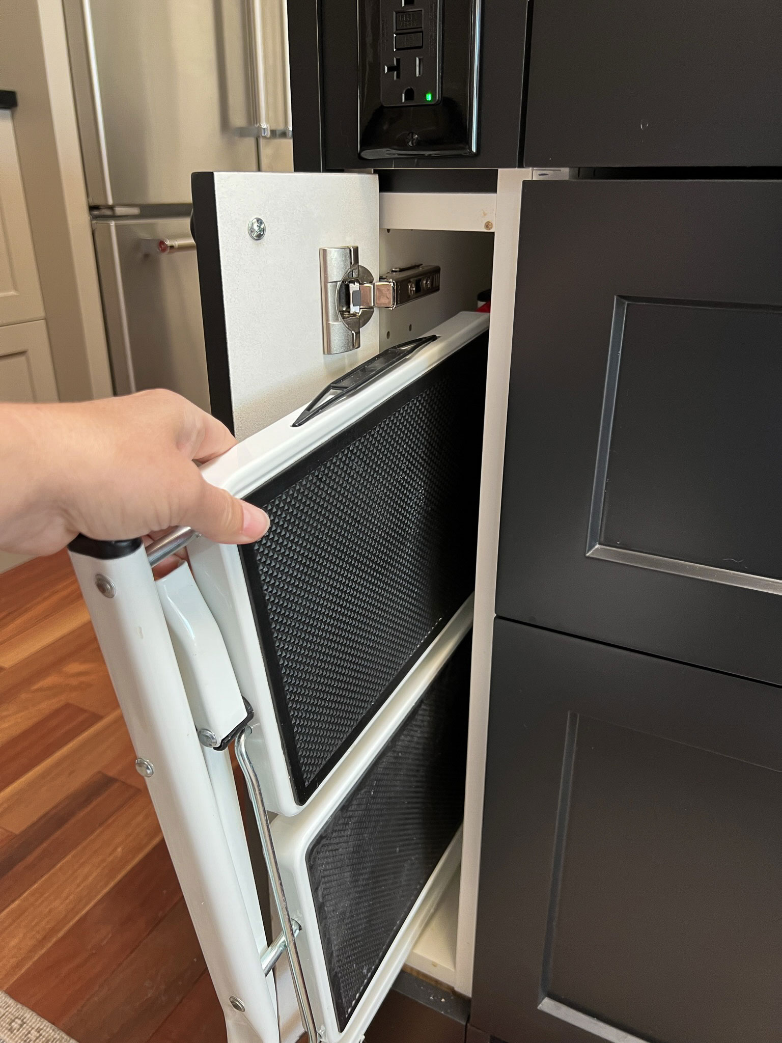 pulling a folding step stool out of the skinny end cabinet