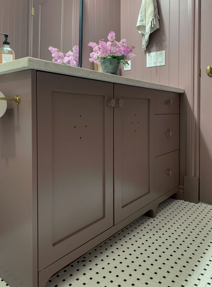 purple bathroom vanity with decorative toe kicks, purple beadboard walls