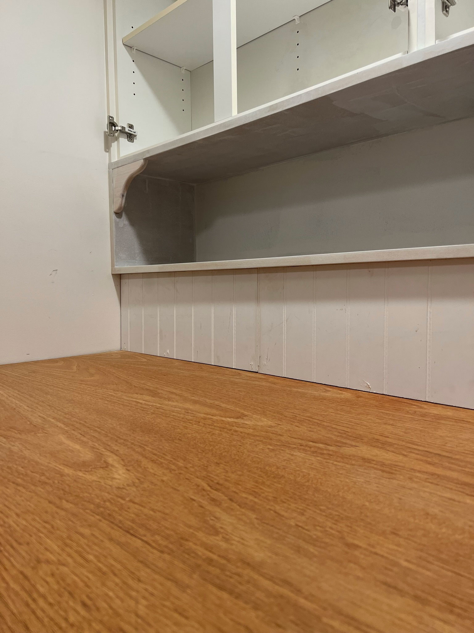 beadboard backsplash with wood DIY laundry room countertop and an unfished shelf and cabients above