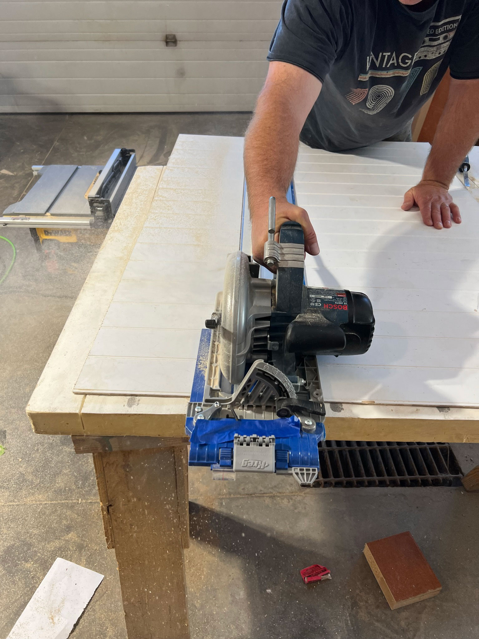 using a circular saw and a guide to cut beadboard paneling on some sawhorses