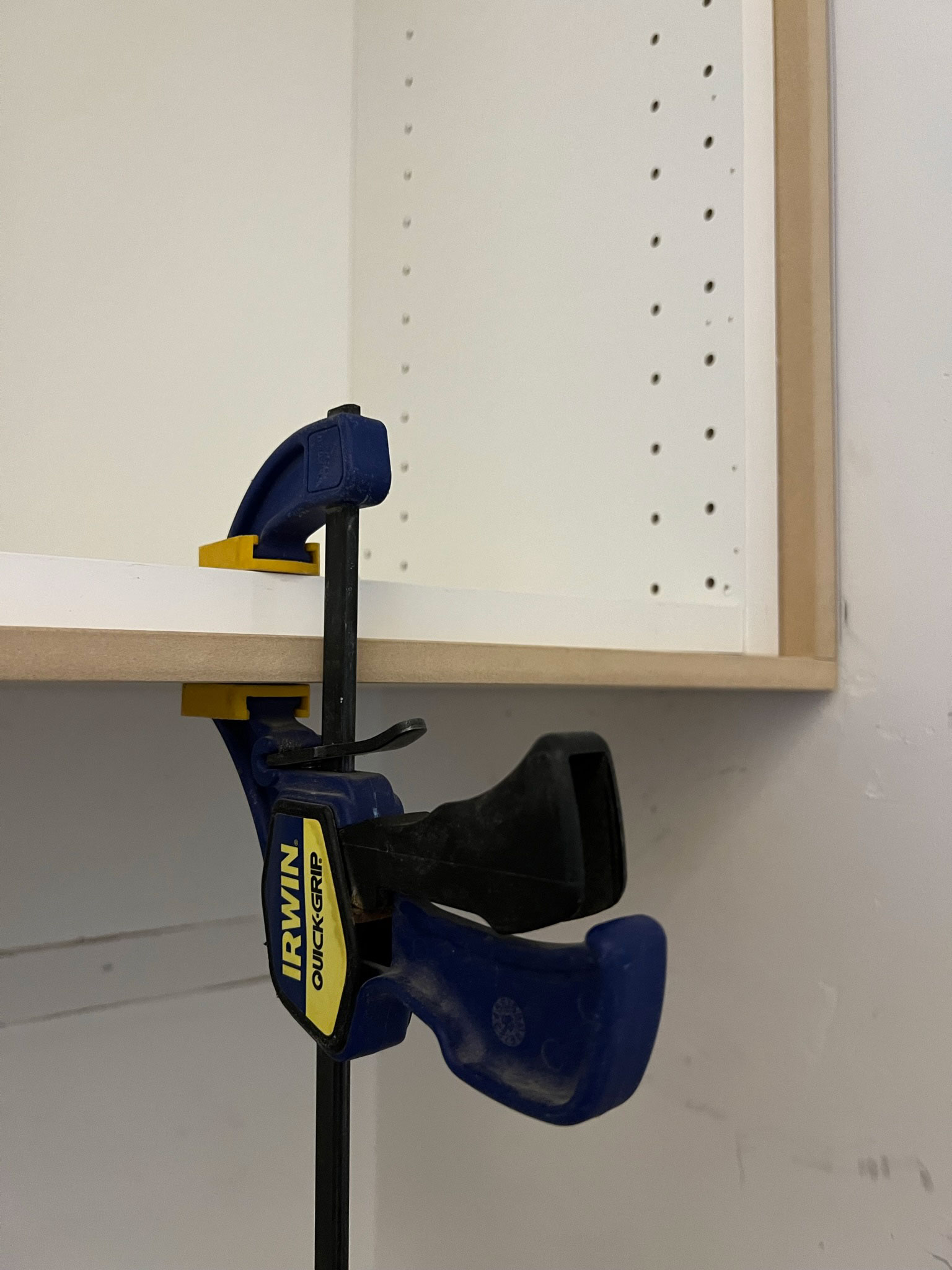 Piece of MDF clamped to the bottom of a cabinet