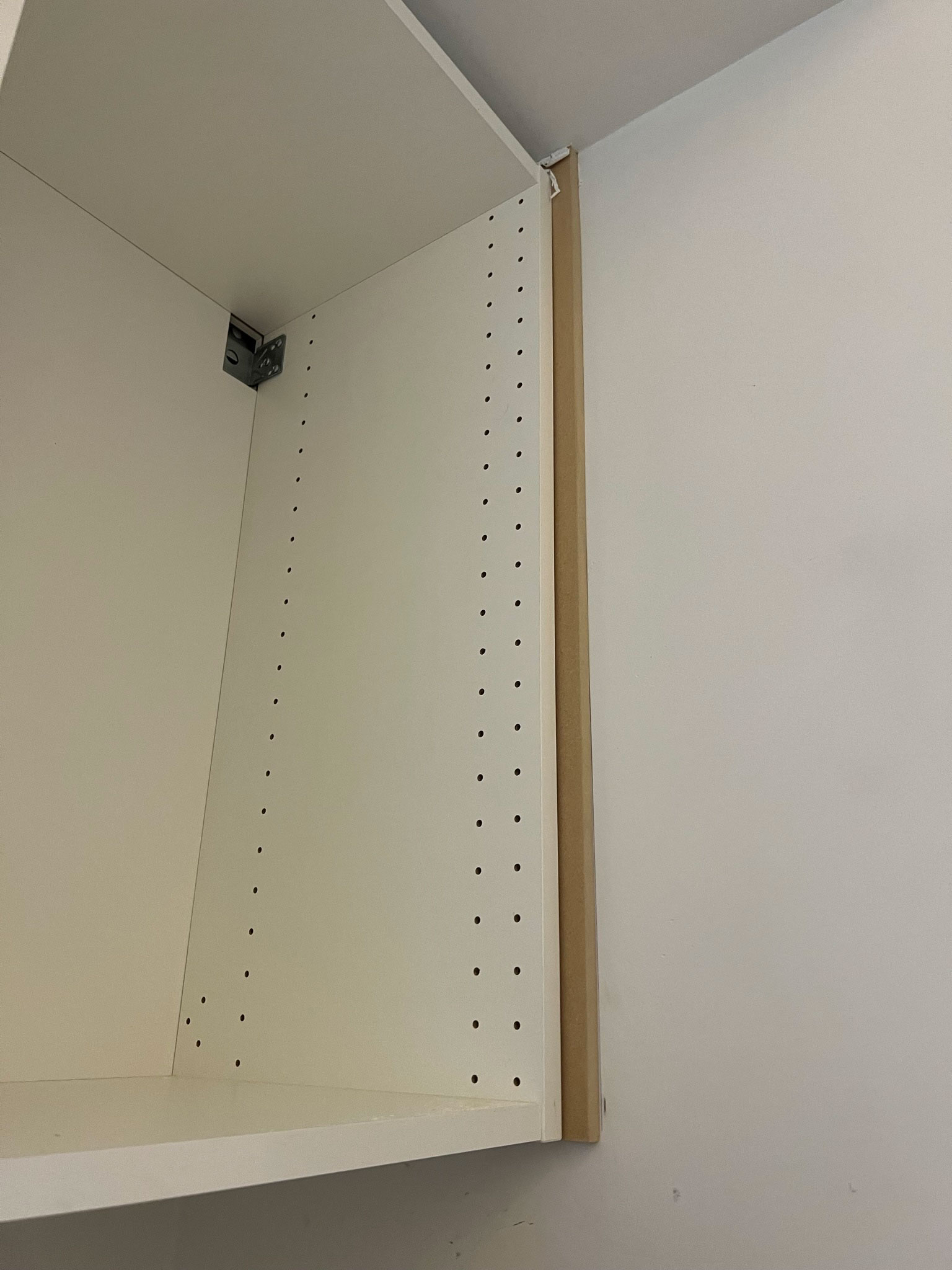 cabinet against wall with side piece of MDF as filler